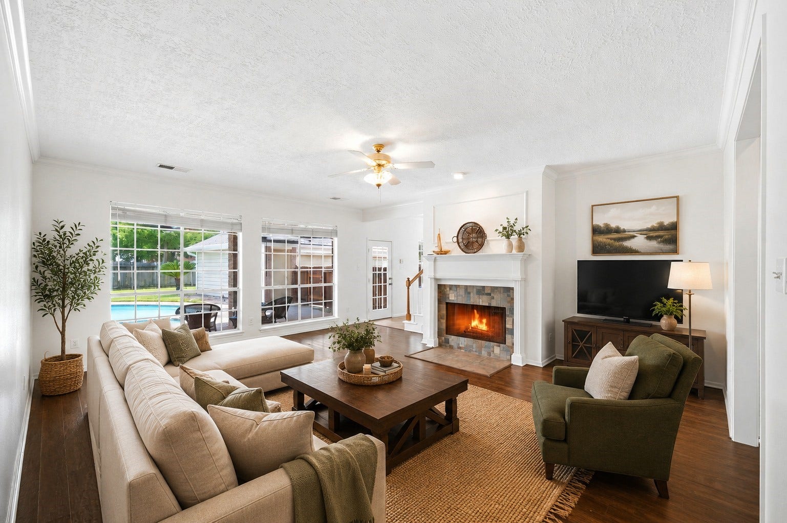 2216 Fairwater Park Drive, League City, TX 77573 The living room offers a cozy fireplace, abundant natural light from large windows, and a stunning view of the backyard pool, creating a perfect blend of comfort and style.