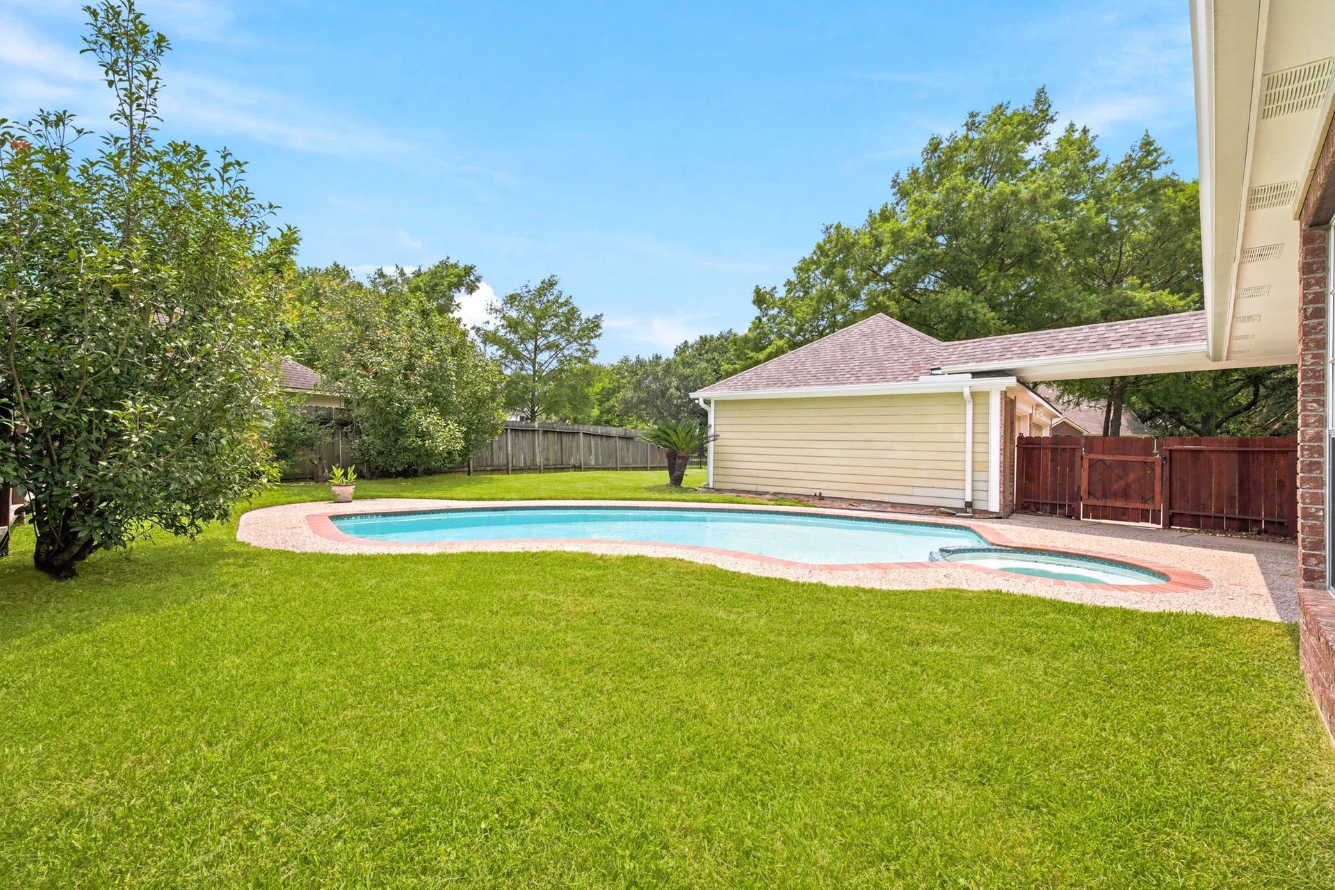 2216 Fairwater Park Drive, League City, TX 77573 Discover your private oasis with a sparkling pool, lush lawn, and mature trees, all enclosed by a charming wooden fenceperfect for relaxation and outdoor fun.