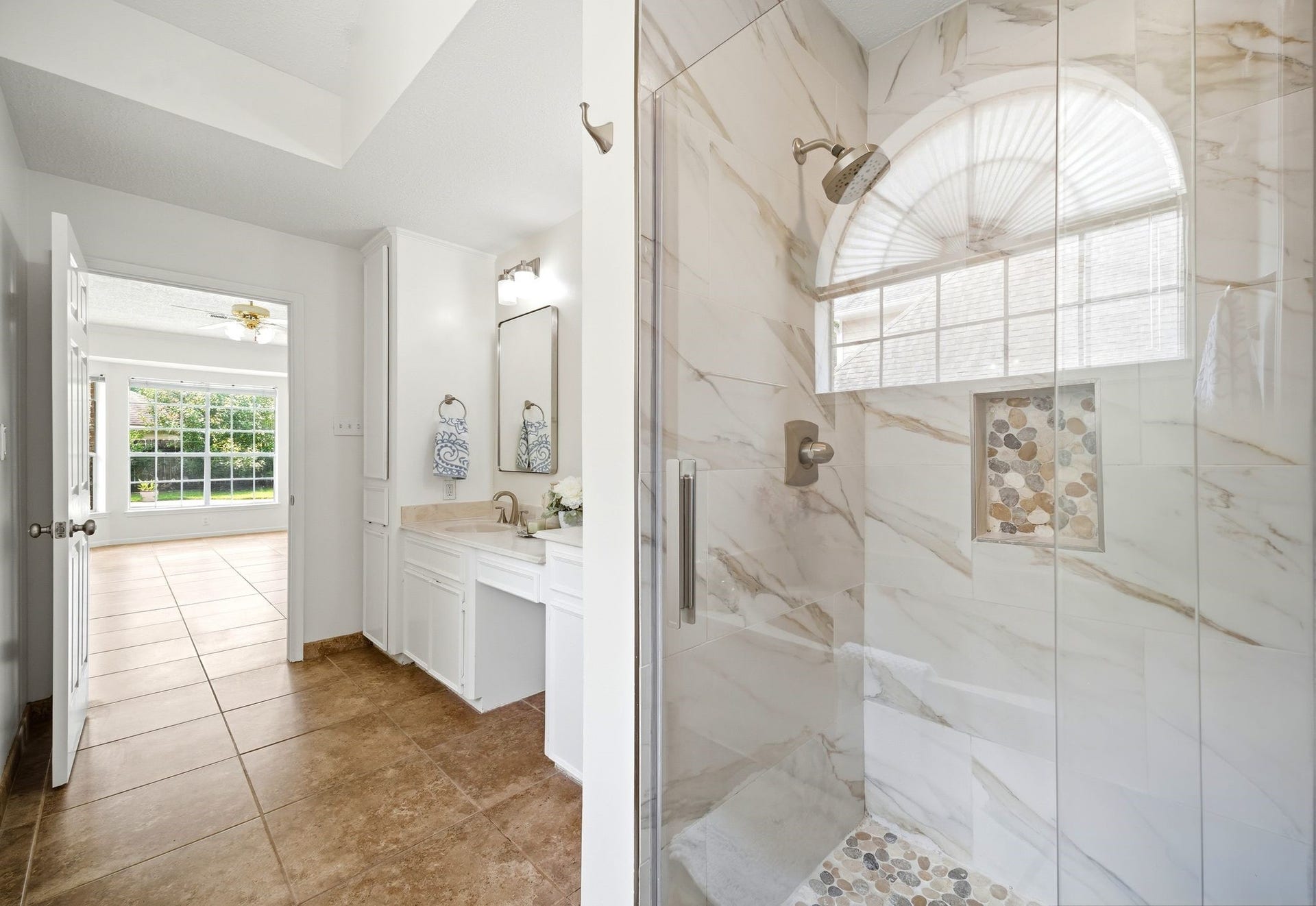 2216 Fairwater Park Drive, League City, TX 77573 Experience luxury in the elegant walk-in shower featuring pebble-like tile and sleek new glass doors.