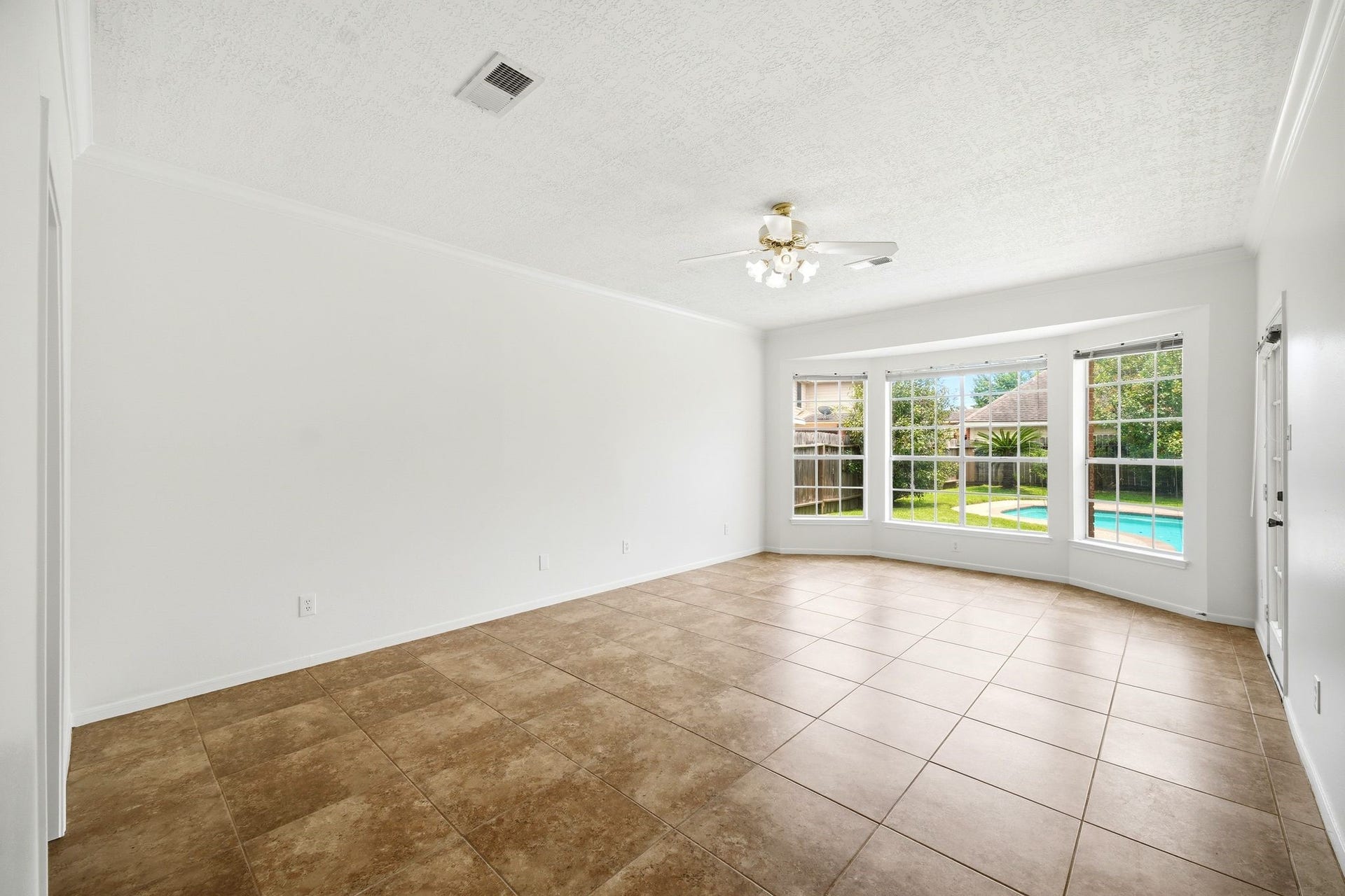 2216 Fairwater Park Drive, League City, TX 77573 Spacious primary bedroom with abundant natural light, featuring large windows overlooking the pool and a versatile open layout perfect for your personal touch.
