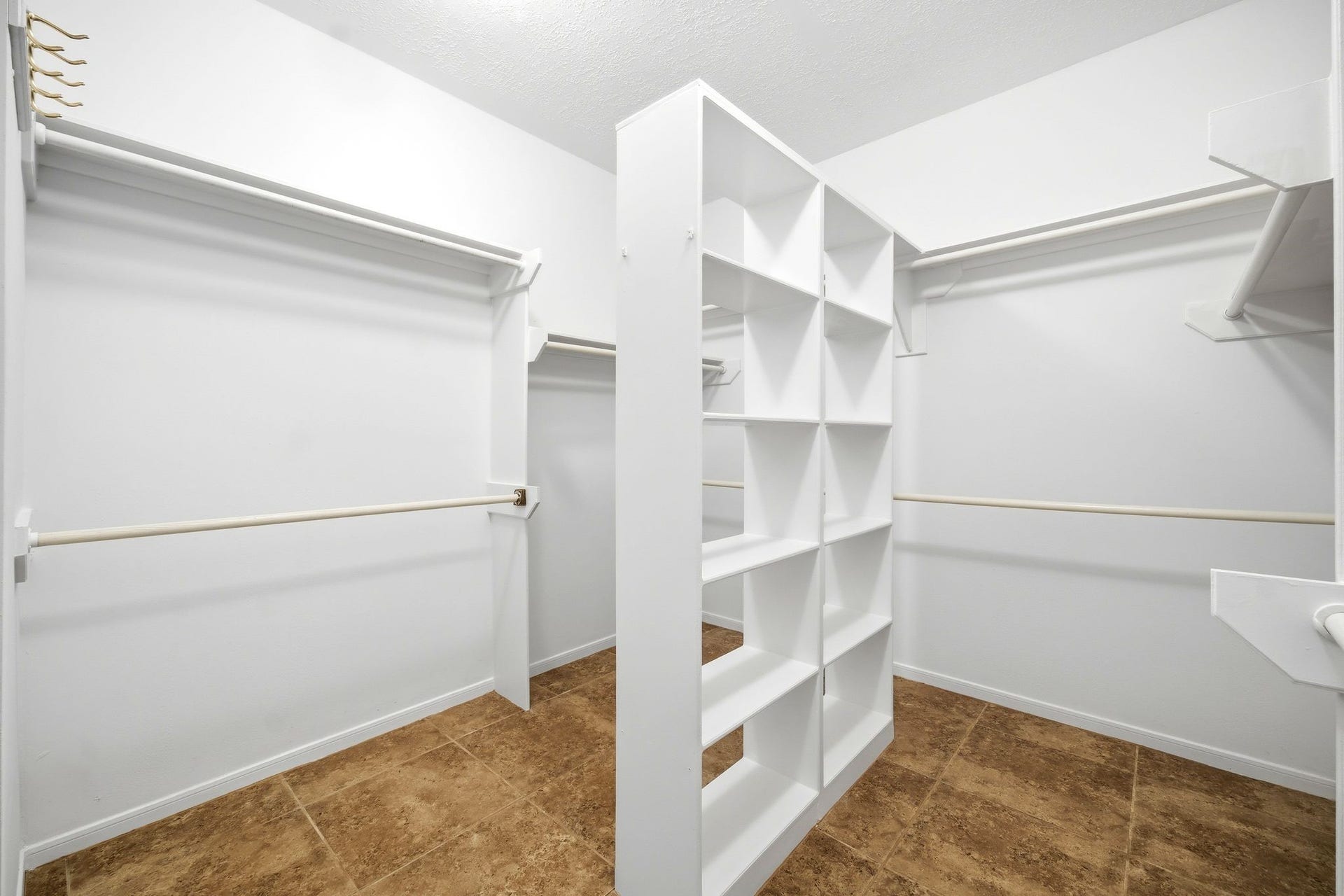 2216 Fairwater Park Drive, League City, TX 77573 Discover the ultimate in organization with this spacious walk-in closet, boasting ample shelving, hanging rods, and a central divider for perfectly arranged storage.