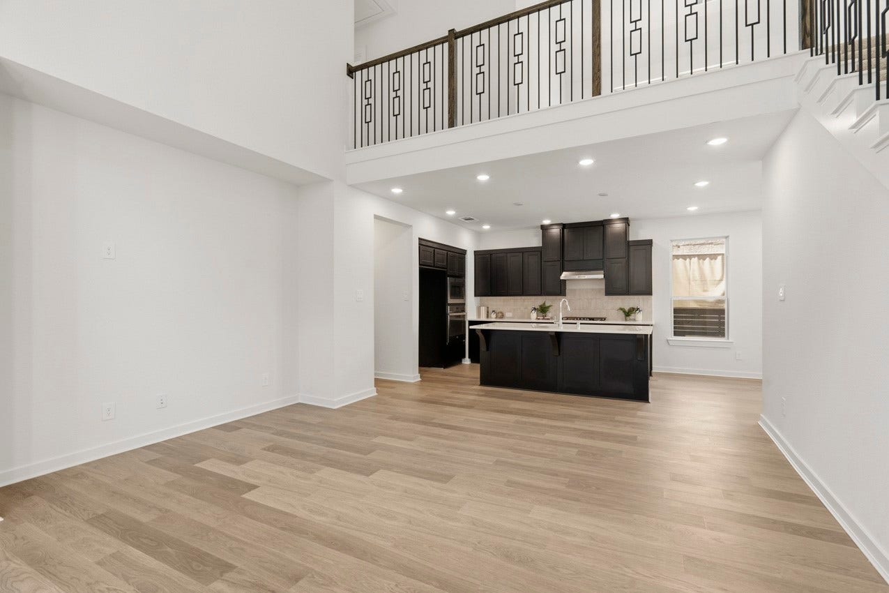 3431 Loam Lane, Richmond, TX 77406 A family room with high ceilings opens to the kitchen and features elegant balusters overlooking the loft creating a bright and connected gathering space.