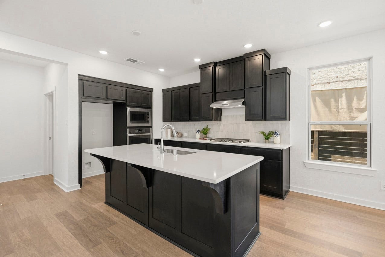 3431 Loam Lane, Richmond, TX 77406 The kitchen features beautiful custom cabinetry and a spacious island, creating a warm and inviting place for family and friends to gather.
