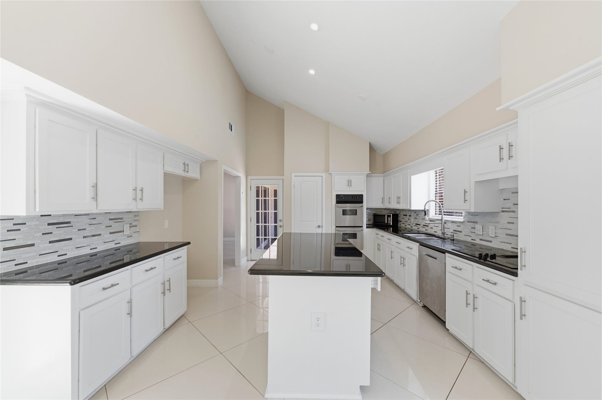 703 Queensmill Court, Houston, TX 77079 The kitchen features a generous center island perfect for prep work and entertaining, plus premium stainless steel appliances including double ovens.