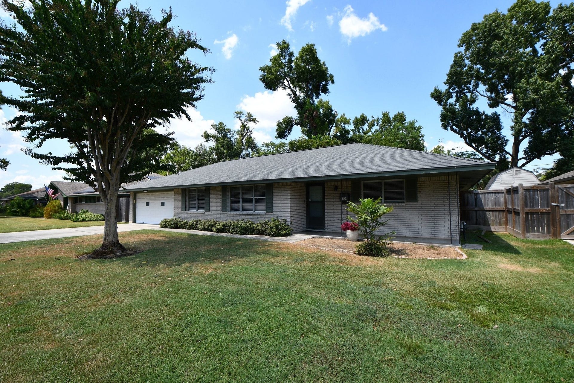9006 Railton Street, Houston, TX 77080 Charming single-story home featuring a well-maintained lawn, mature trees, and a welcoming front entry.