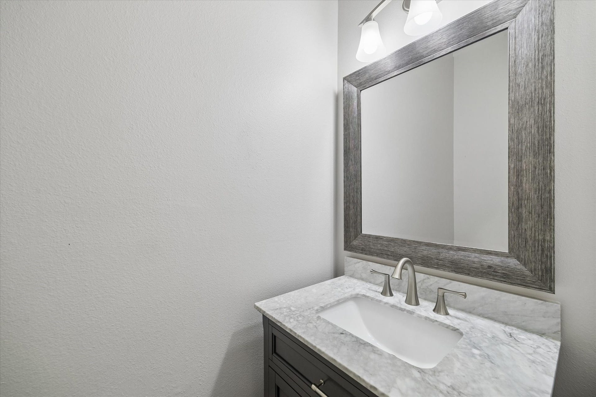 21519 Black Opal Lane, Kingwood, TX 77339 A half-bath is conveniently located on the first floor and features an updated vanity, faucet, framed mirror, and lighting.