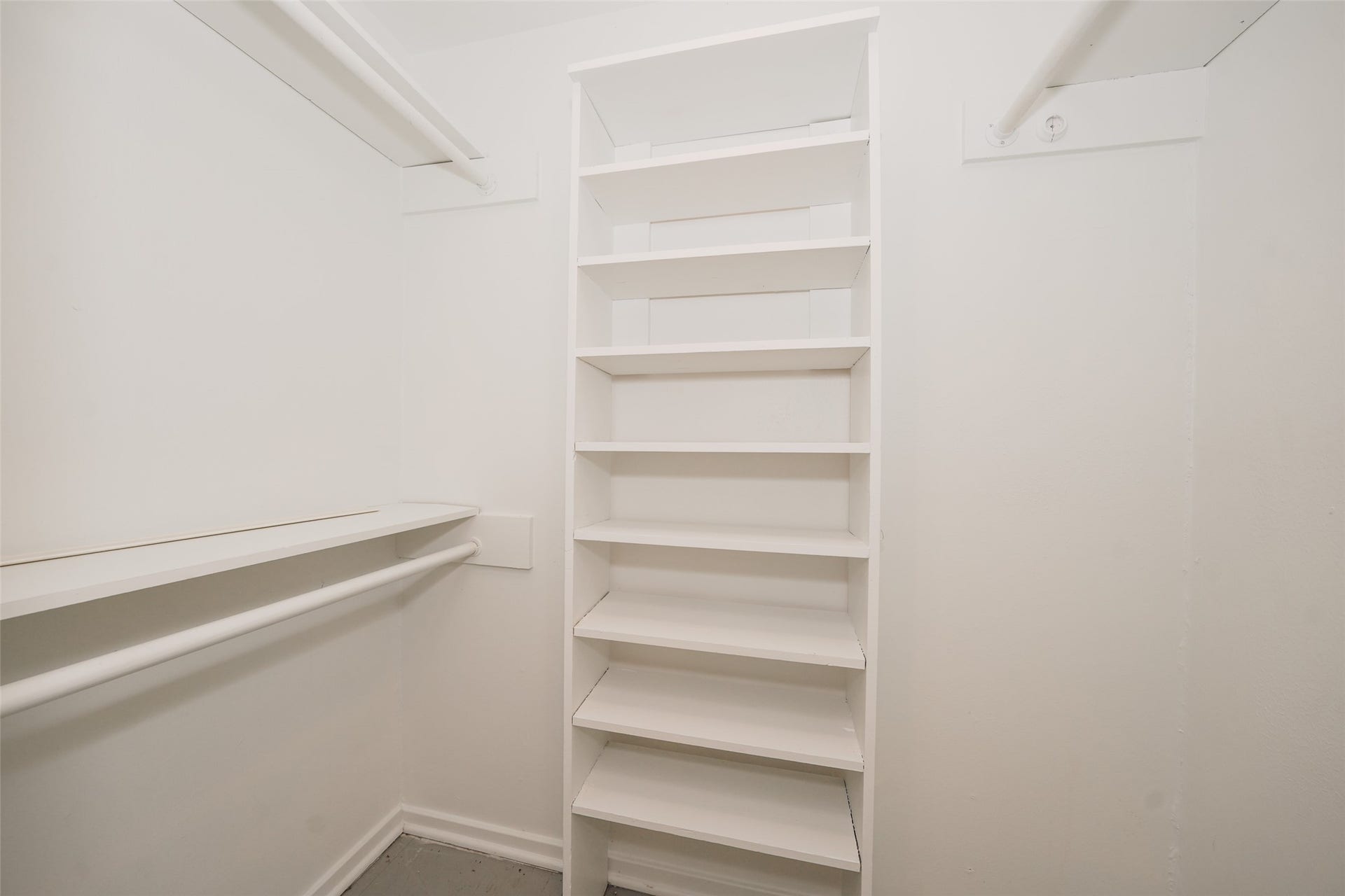 9519 Val Verde Street, Houston, TX 77063 This photo shows a spacious walk-in closet with white shelves and hanging rods, offering ample storage and organization options.