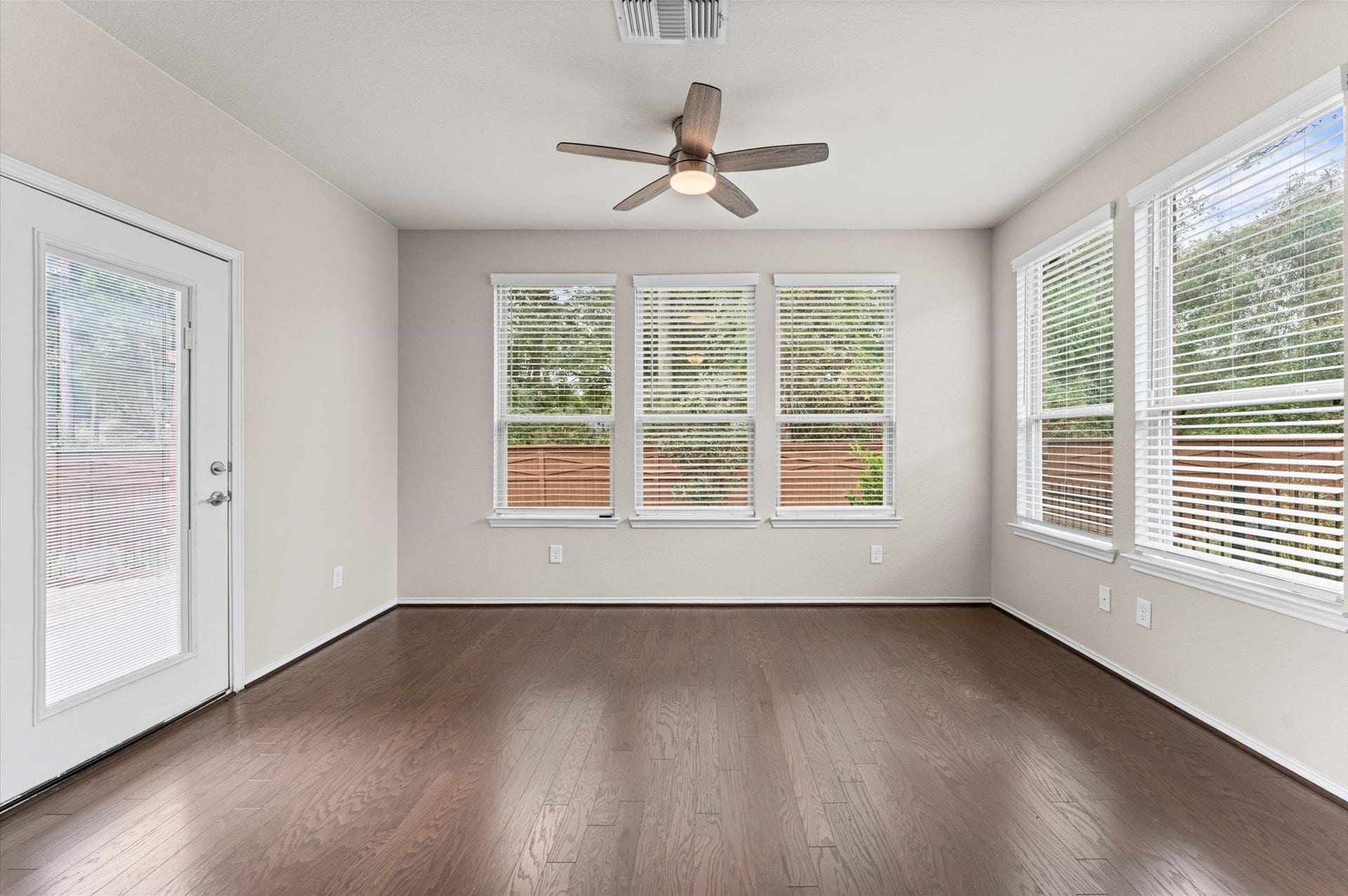 317 Fell Lane, Spring, TX 77382 Spilling outward from the central living area, the sunroom boasts large windows that frame sweeping, unobstructed sightlines of the protected, mature green space behind the property.