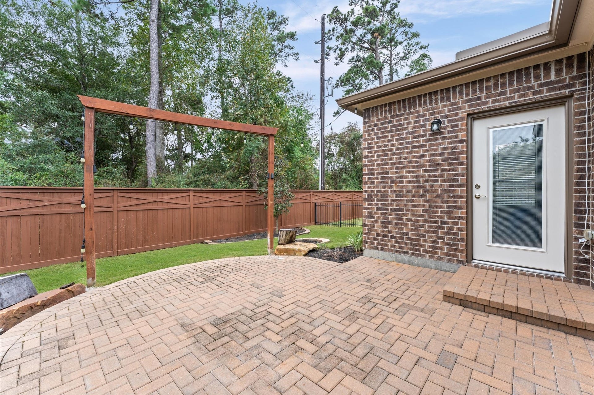 317 Fell Lane, Spring, TX 77382 The backyard patio optimized for both personal relaxation and entertaining guests, allowing people to socialize, dine, or lounge comfortably without crowding the space.