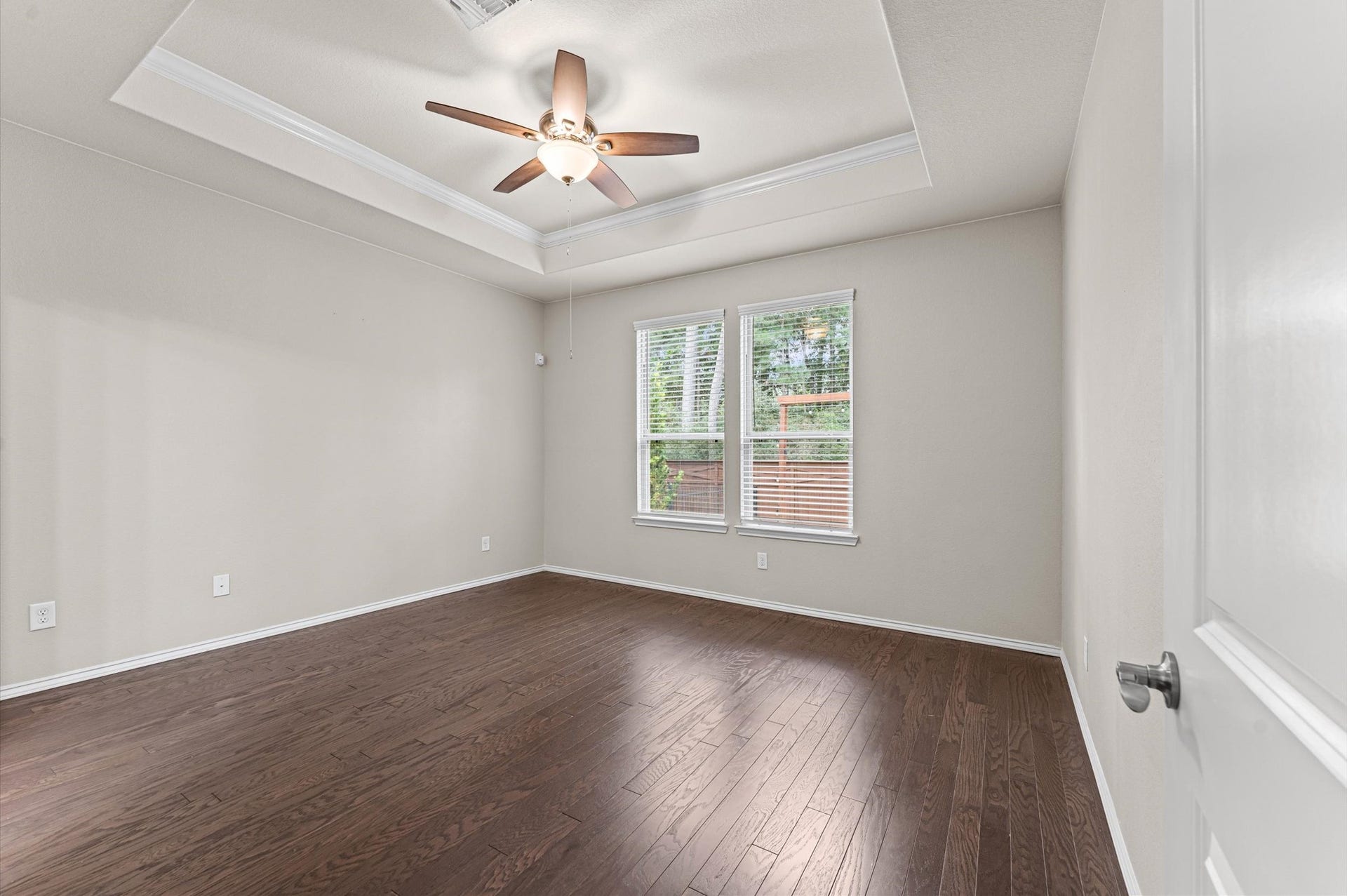 317 Fell Lane, Spring, TX 77382 The spacious and inviting primary suite features high ceilings, a beautiful view to the green space behind the property and modern en-suite bathroom.
