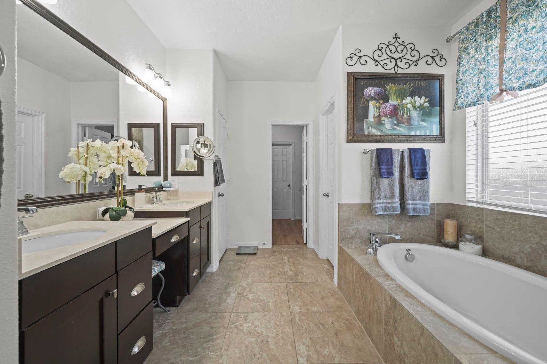 28107 Scenic Shore Lane, Fulshear, TX 77441 Spacious bathroom featuring a luxurious soaking tub, dual sinks with elegant dark wood cabinetry, and ample natural light.