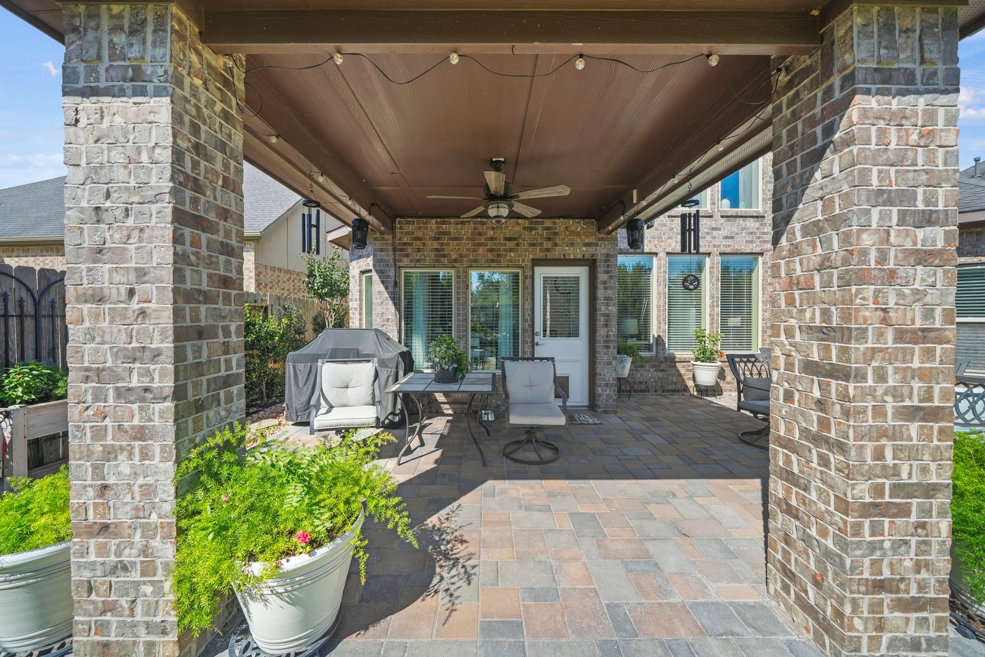 28107 Scenic Shore Lane, Fulshear, TX 77441 Charming covered patio with brick accents and ample seating, perfect for outdoor entertaining.