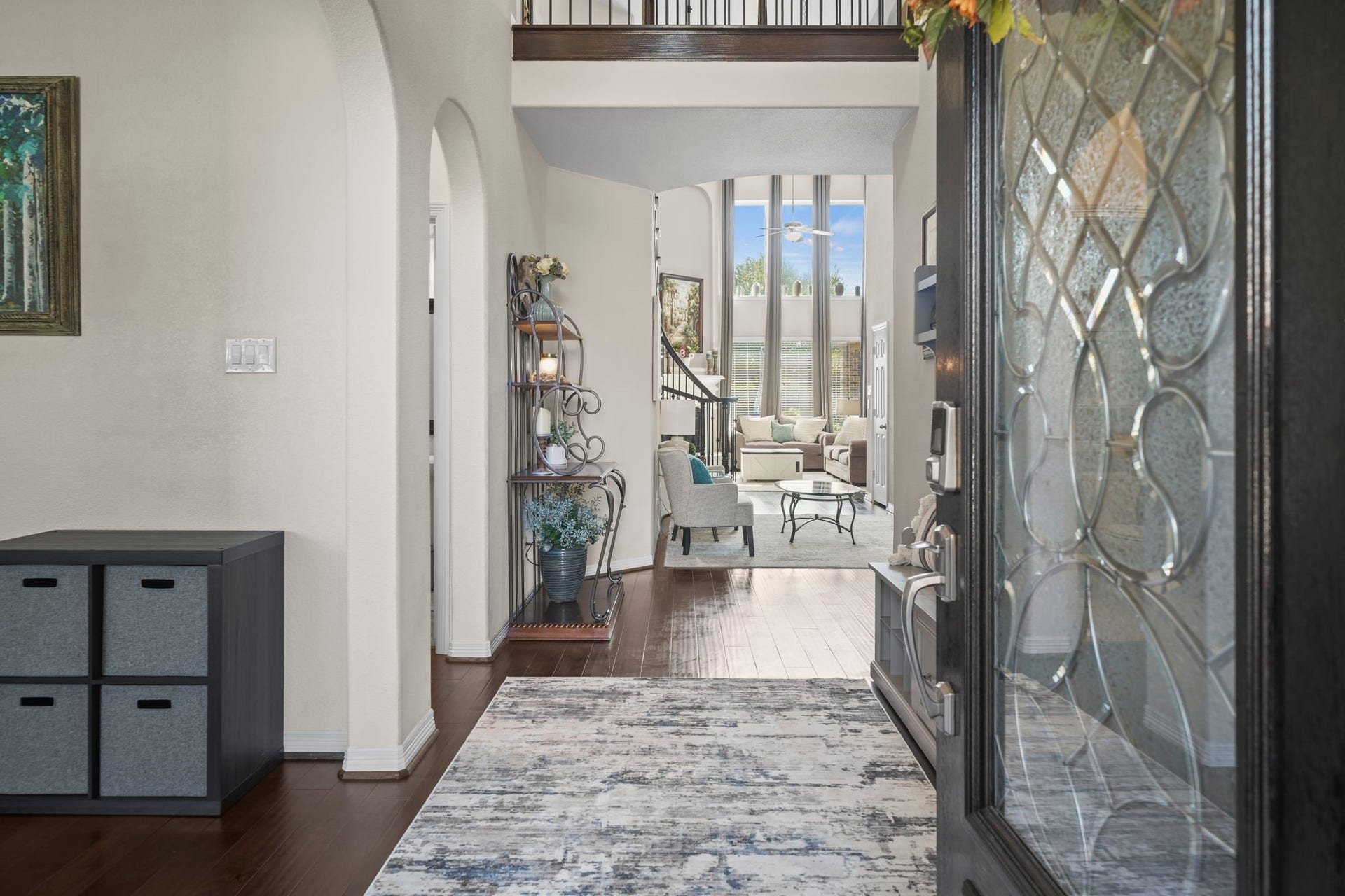 28107 Scenic Shore Lane, Fulshear, TX 77441 Step into an inviting entryway with elegant hardwood floors leading to a spacious living area. Soaring ceilings and abundant natural light create a bright, open atmosphere perfect for relaxing or entertaining.