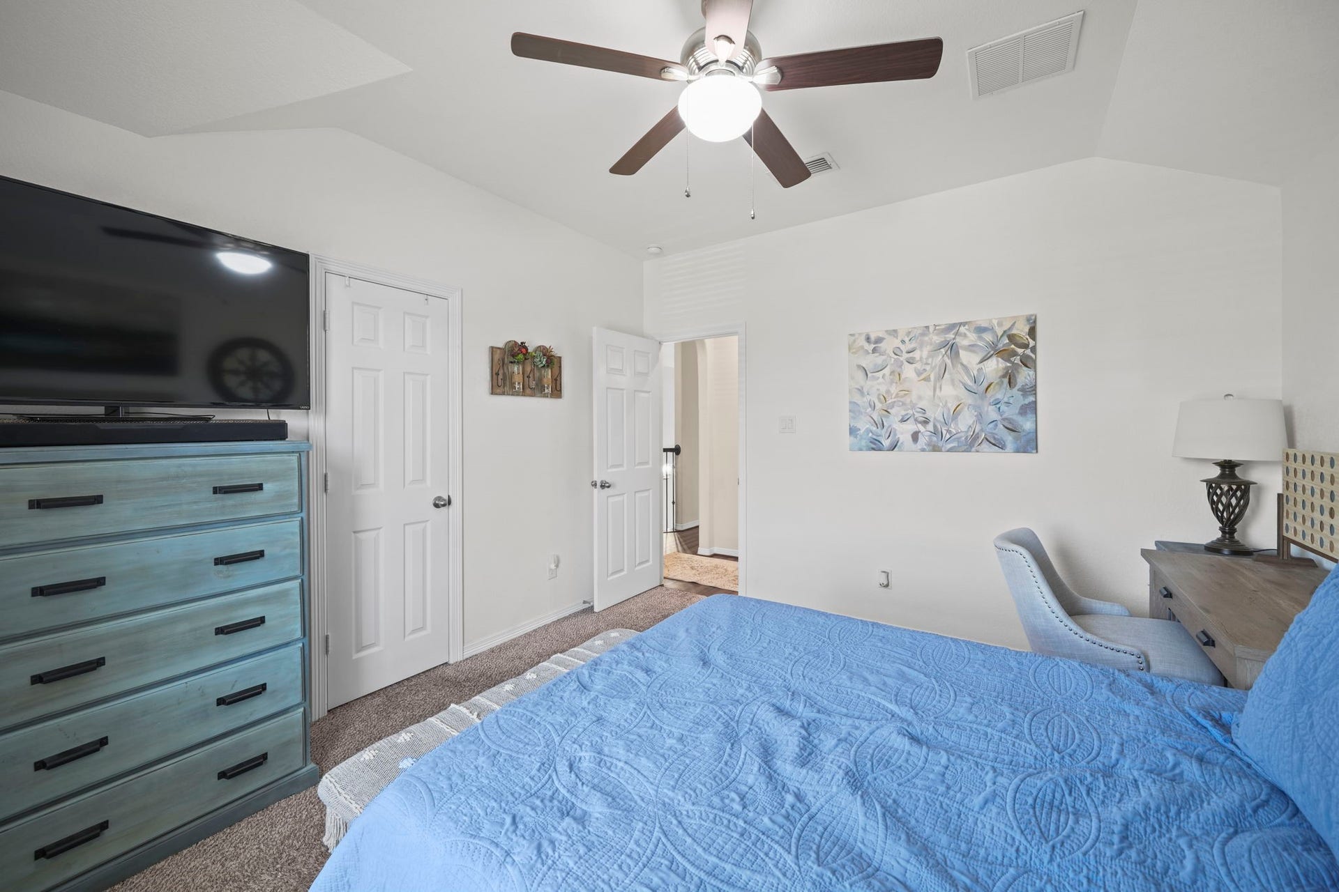 28107 Scenic Shore Lane, Fulshear, TX 77441 Bright and inviting bedroom featuring a vaulted ceiling, modern ceiling fan, and ample space with a stylish dresser and cozy workspace.