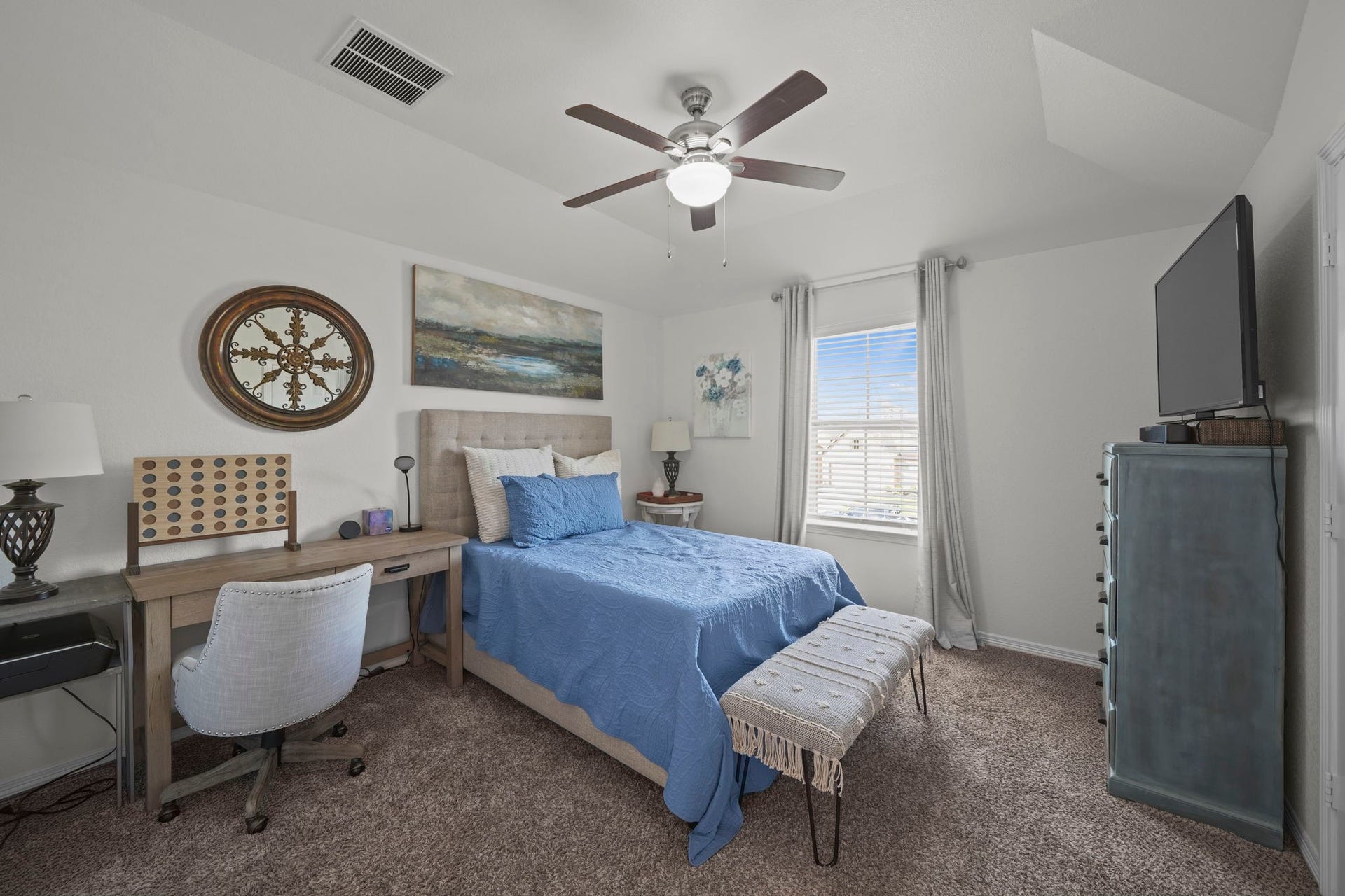 28107 Scenic Shore Lane, Fulshear, TX 77441 Cozy bedroom with a soft blue palette, featuring a comfortable bed, stylish decor, and ample natural light through a large window, perfect for relaxation.