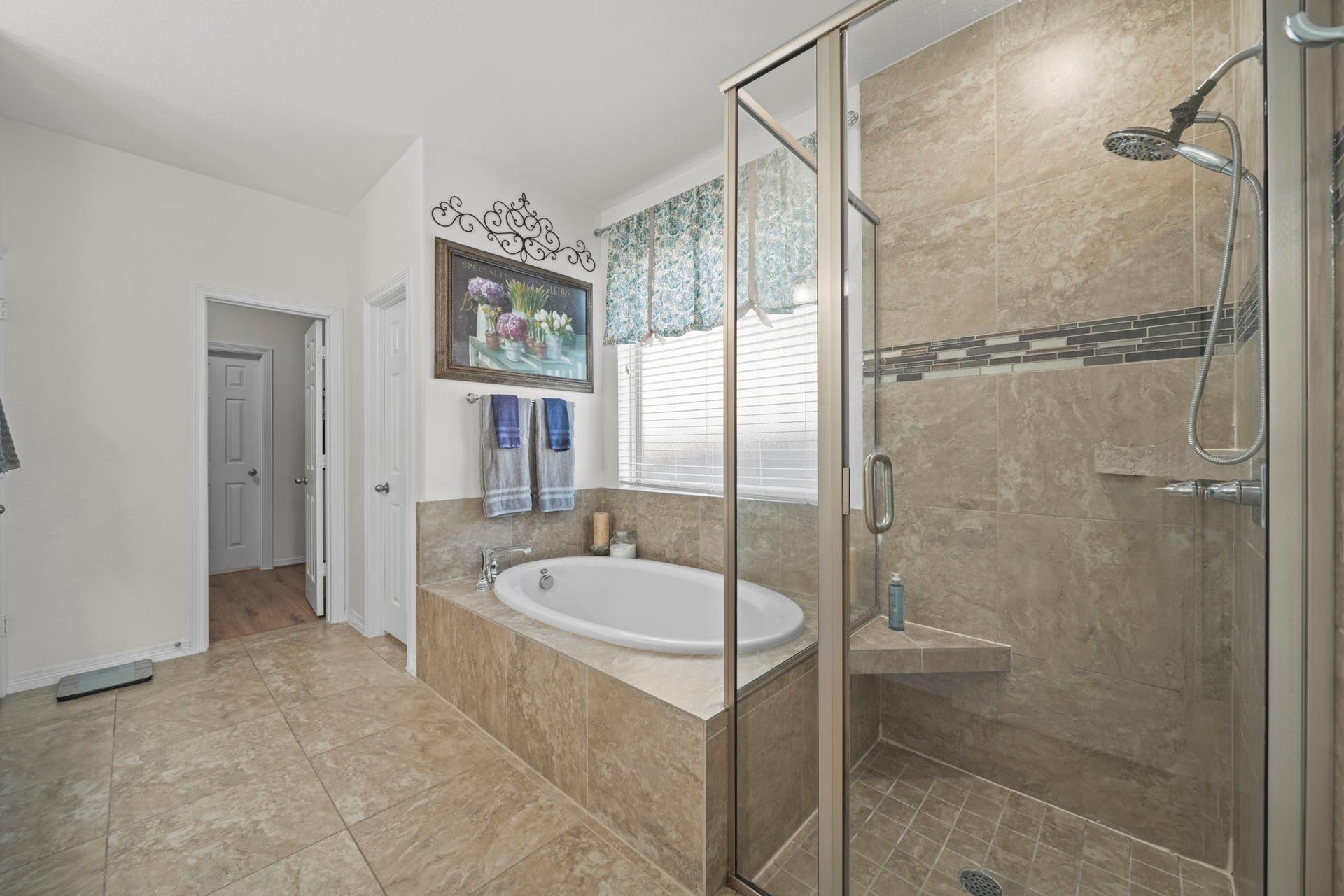 28107 Scenic Shore Lane, Fulshear, TX 77441 Luxurious bathroom featuring a spacious walk-in shower and a relaxing soaking tub, accented by elegant tile work and ample natural light.