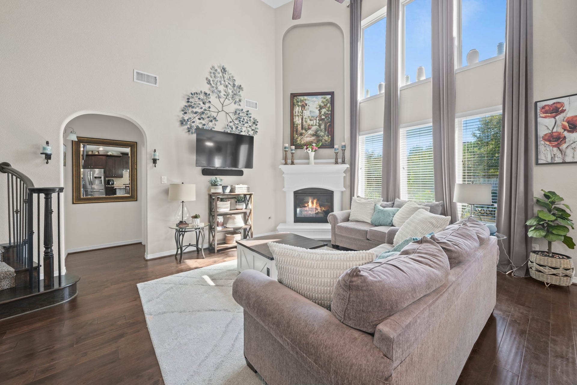 28107 Scenic Shore Lane, Fulshear, TX 77441 Spacious living room with soaring ceilings, a cozy fireplace, and abundant natural light from large windows, creating a welcoming and elegant atmosphere.