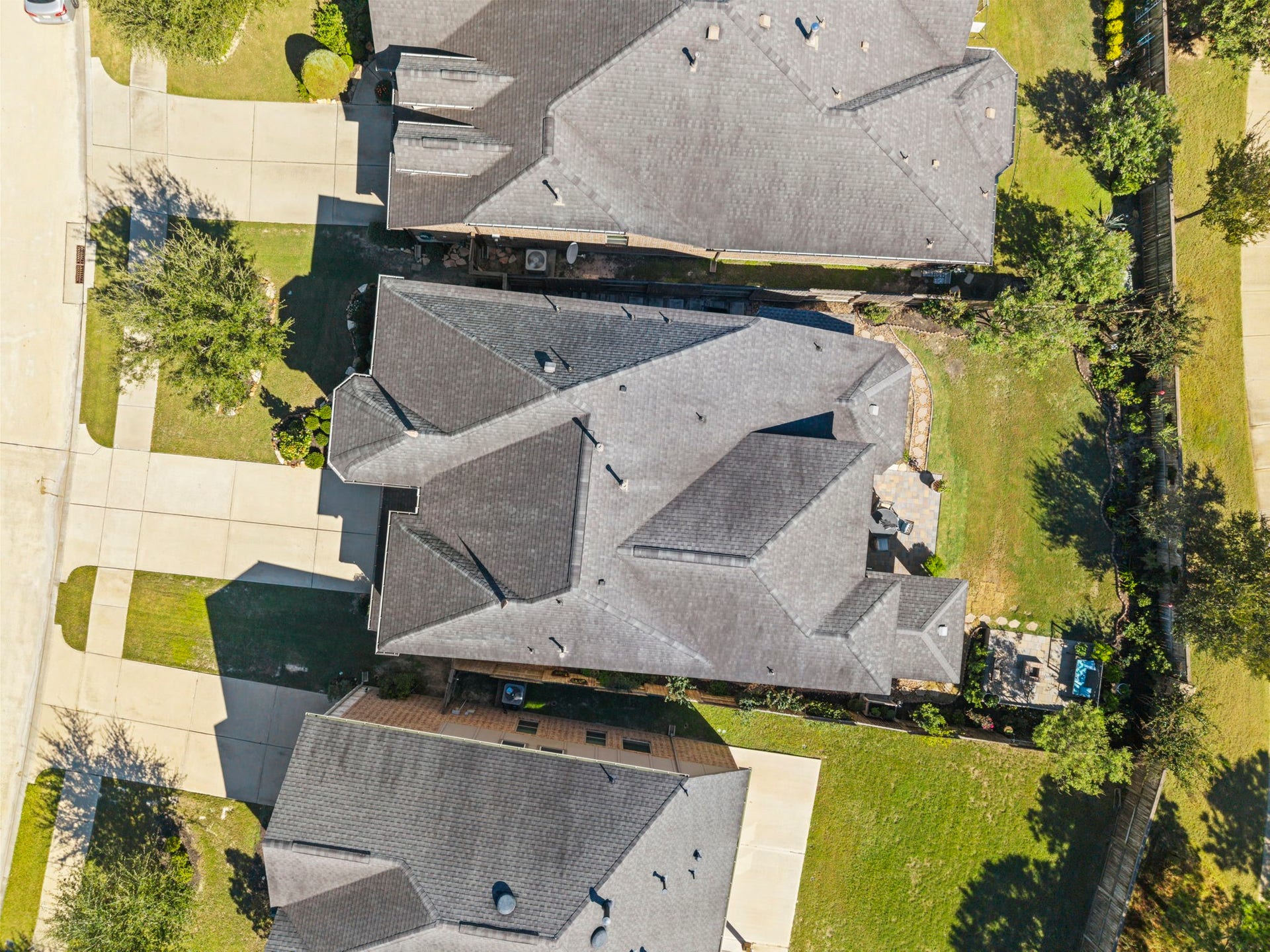 28107 Scenic Shore Lane, Fulshear, TX 77441 Aerial view of a spacious property featuring a large, well-maintained roof and expansive driveways, surrounded by lush greenery and a fenced backyard, offering ample outdoor space.