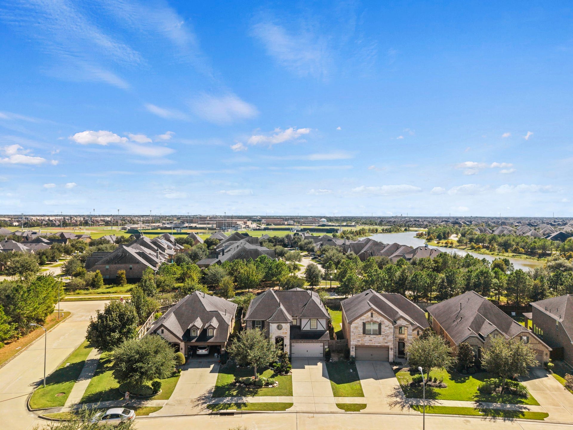 28107 Scenic Shore Lane, Fulshear, TX 77441 Nestled in a serene neighborhood, this charming home offers a picturesque view of lush greenery and tranquil water features, perfect for peaceful living.