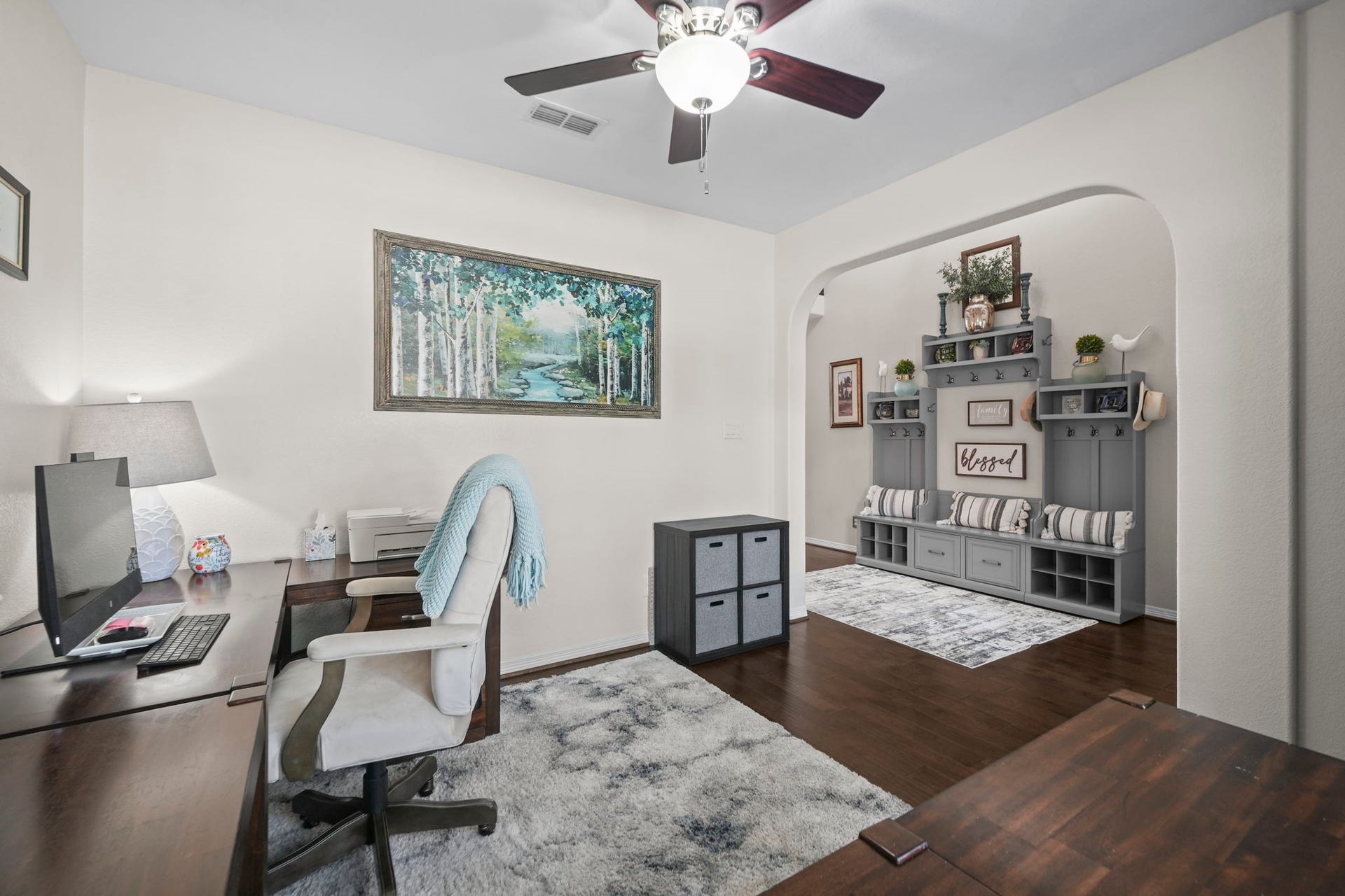28107 Scenic Shore Lane, Fulshear, TX 77441 Elegant home office with warm wooden flooring, a cozy workspace, and stylish built-in shelving perfect for organization.