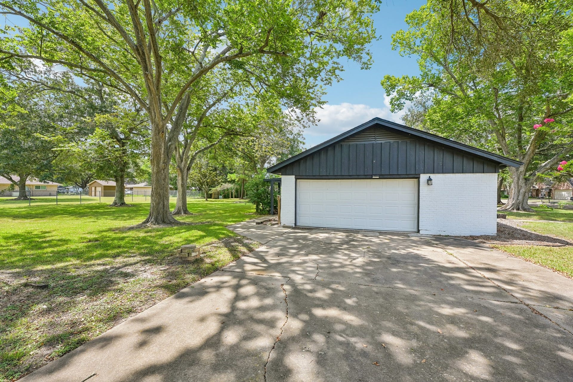 101 W Larkspur Drive, Alvin, TX 77511 Double wide driveway, 2 car garage, and extra garage space for a workshop area.