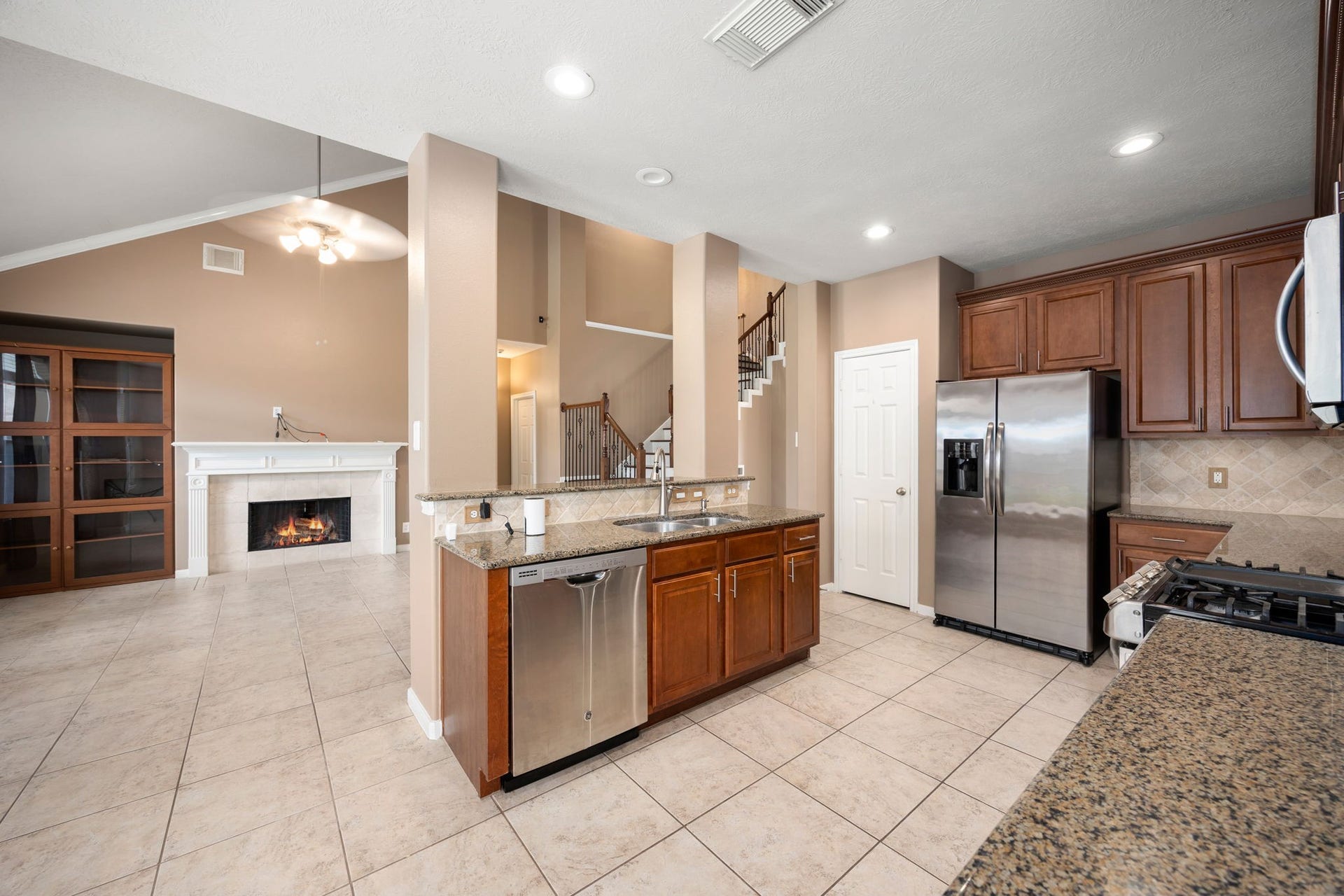 Enjoy a commanding view from the heart of the home! The central kitchen island keeps the chef fully connected to the dramatic, vaulted family room and cozy fireplace, making it the perfect hub for entertaining guests.
