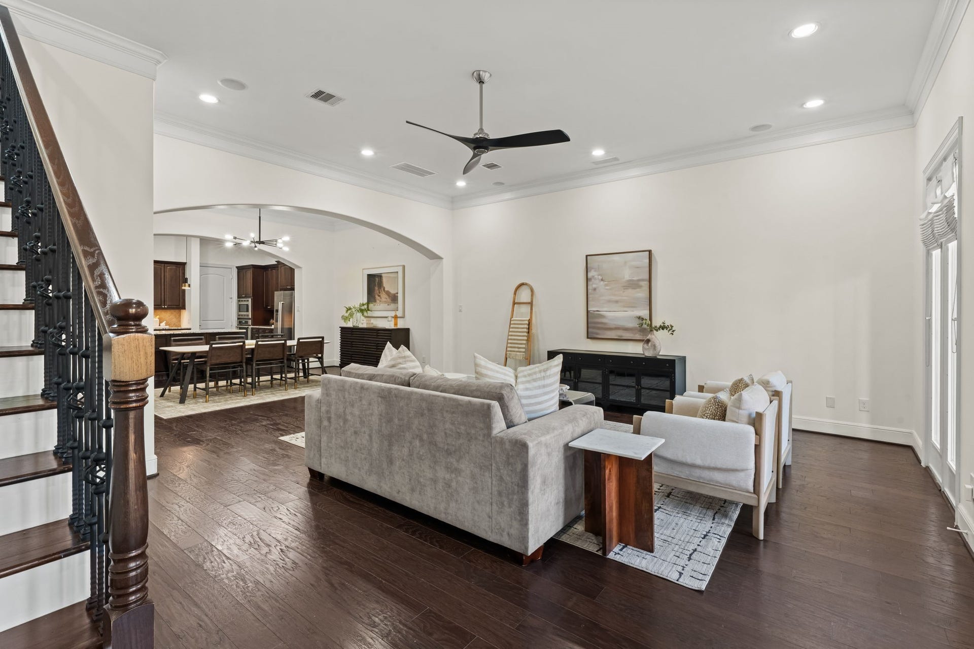 1423 Knox Street, Houston, TX 77007 Architectural arches and rich wood floors bring warmth and definition to the open living space. The layout maintains an easy connection to dining while preserving distinct functional zones.