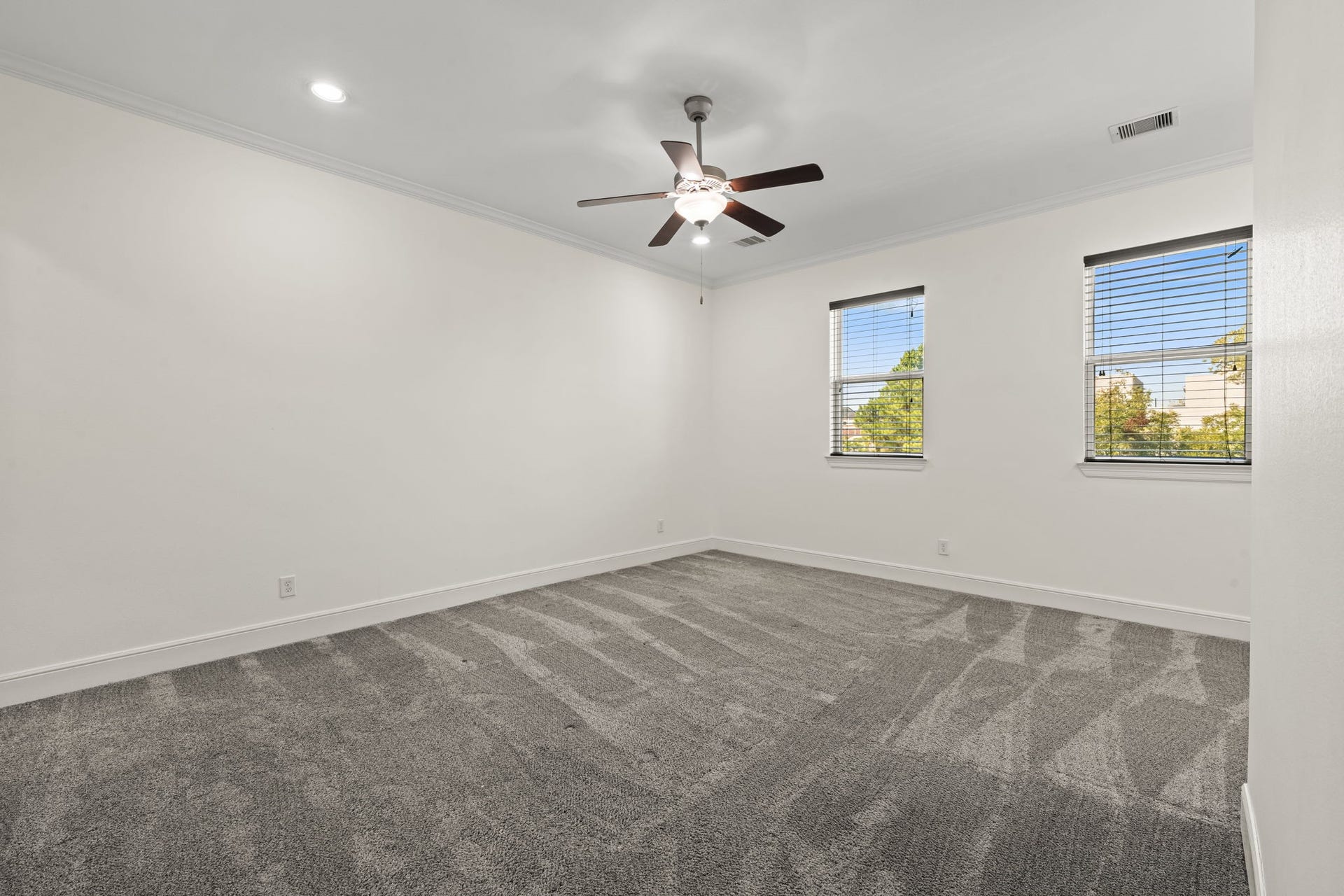 1423 Knox Street, Houston, TX 77007 The third-floor bedroom is notably spacious, with multiple windows and a ceiling fan. Neutral carpeting and clean lines provide a versatile backdrop for guests or a private retreat.