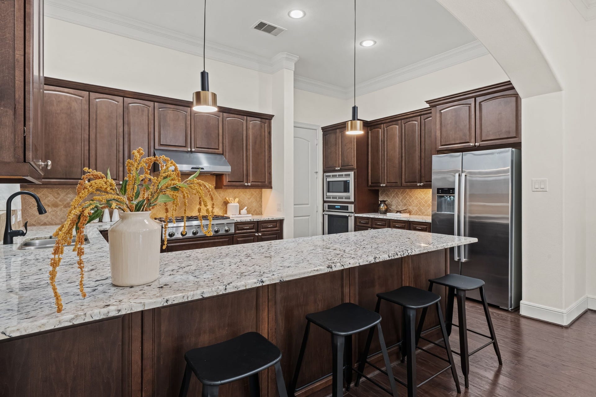 1423 Knox Street, Houston, TX 77007 A spacious center island anchors the kitchen and provides abundant preparation space. Pendant lighting and finely finished cabinetry give the room a sophisticated, cohesive character.