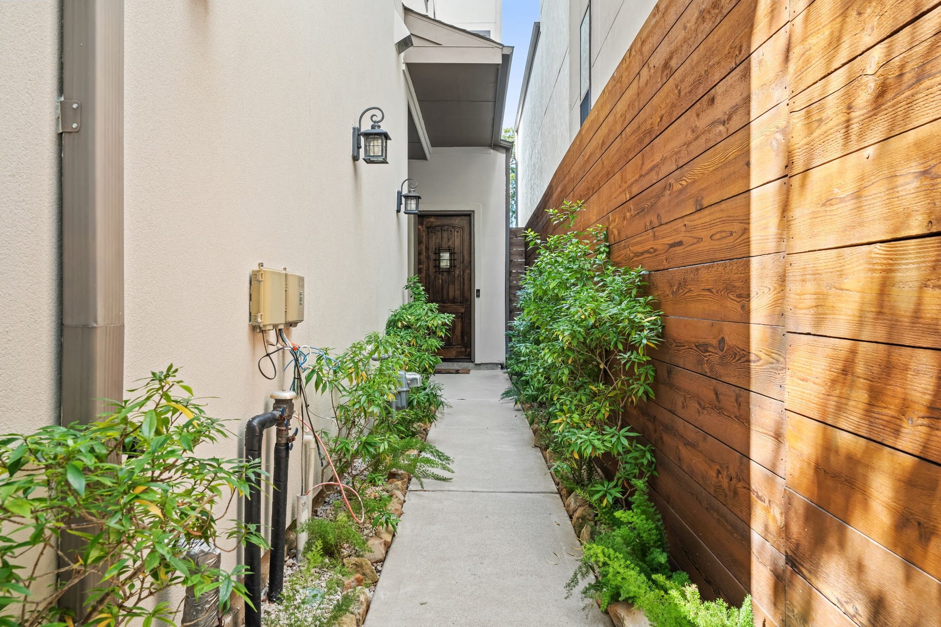 1423 Knox Street, Houston, TX 77007 A landscaped approach creates a private and welcoming transition into the home. Mature greenery and clean architectural lines lend a polished first impression.