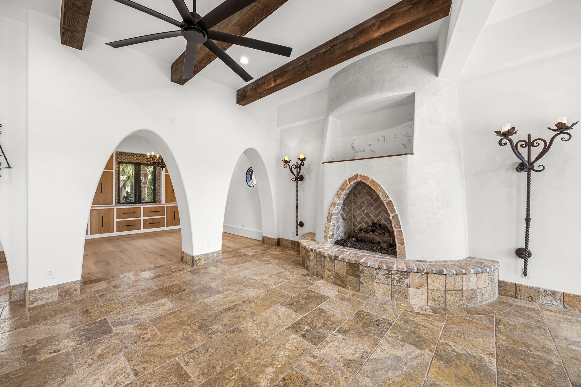721 Harborside Way, League City, TX 77565 The living room offers a stunning perspective through a series of arched openings leading to the formal dining room, creating a seamless blend of sophistication and architectural charm.
