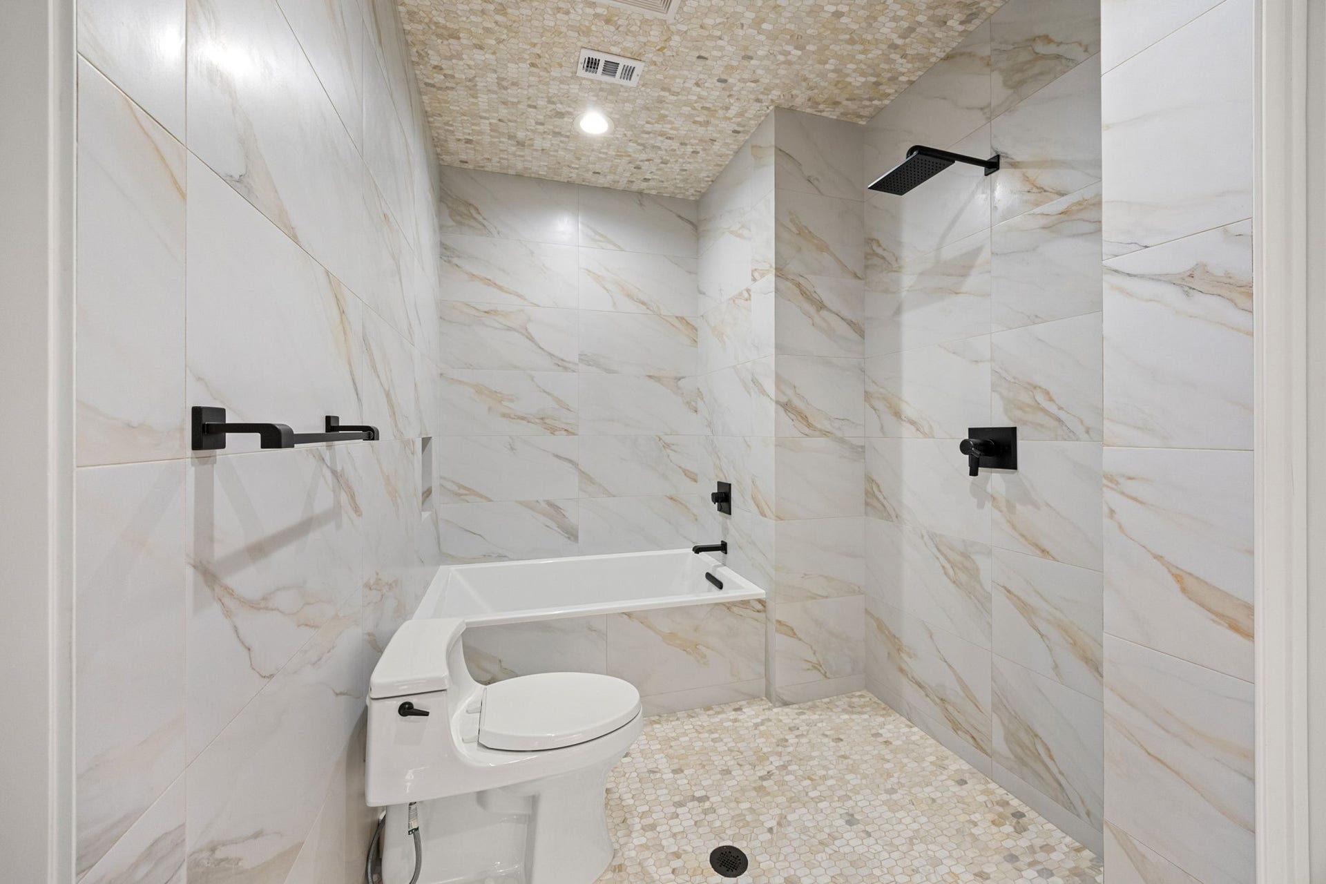 721 Harborside Way, League City, TX 77565 The downstairs primary bath features a modern wet room design, seamlessly integrating the shower, soaking tub, and toilet for a sleek, easy-to-maintain space.