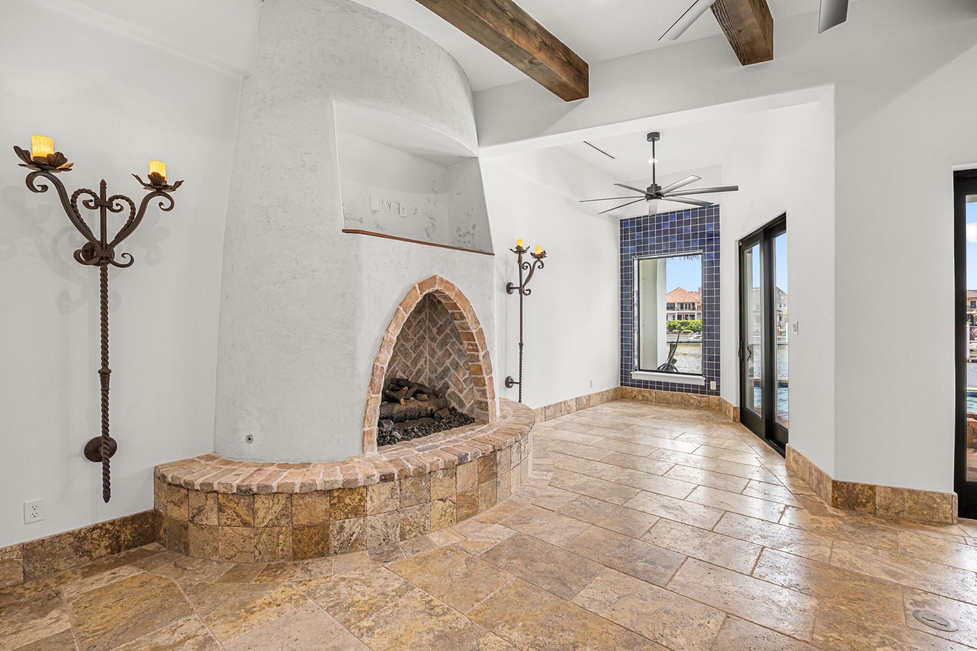 721 Harborside Way, League City, TX 77565 Rich travertine flooring flows throughout the living spaces, anchored by a custom-designed fireplace and complemented by views into the breakfast room, where Spanish tile accents add warmth and timeless Mediterranean charm.