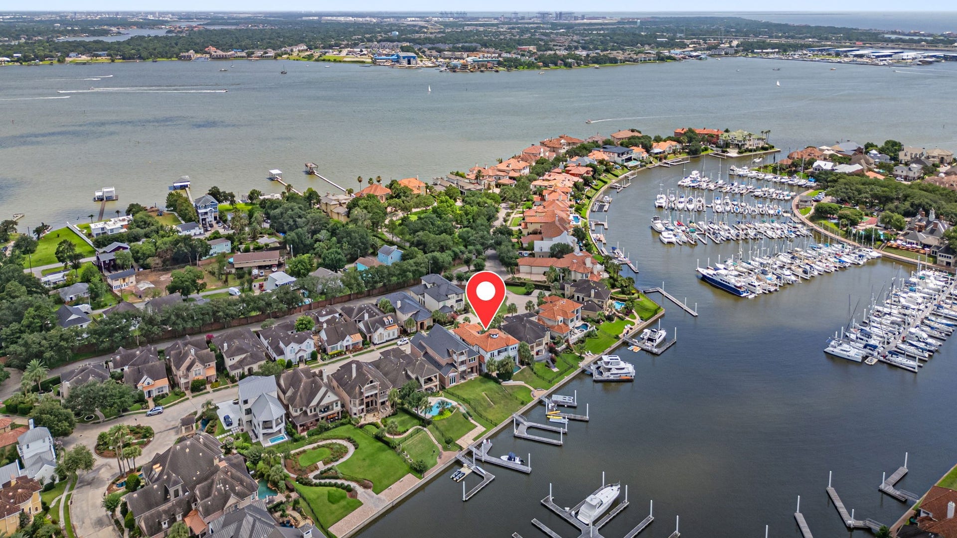 721 Harborside Way, League City, TX 77565 From above, the home and marina are beautifully framed by the surrounding waterways, including a narrow deep-water exit that offers controlled access and added protection from the bay.