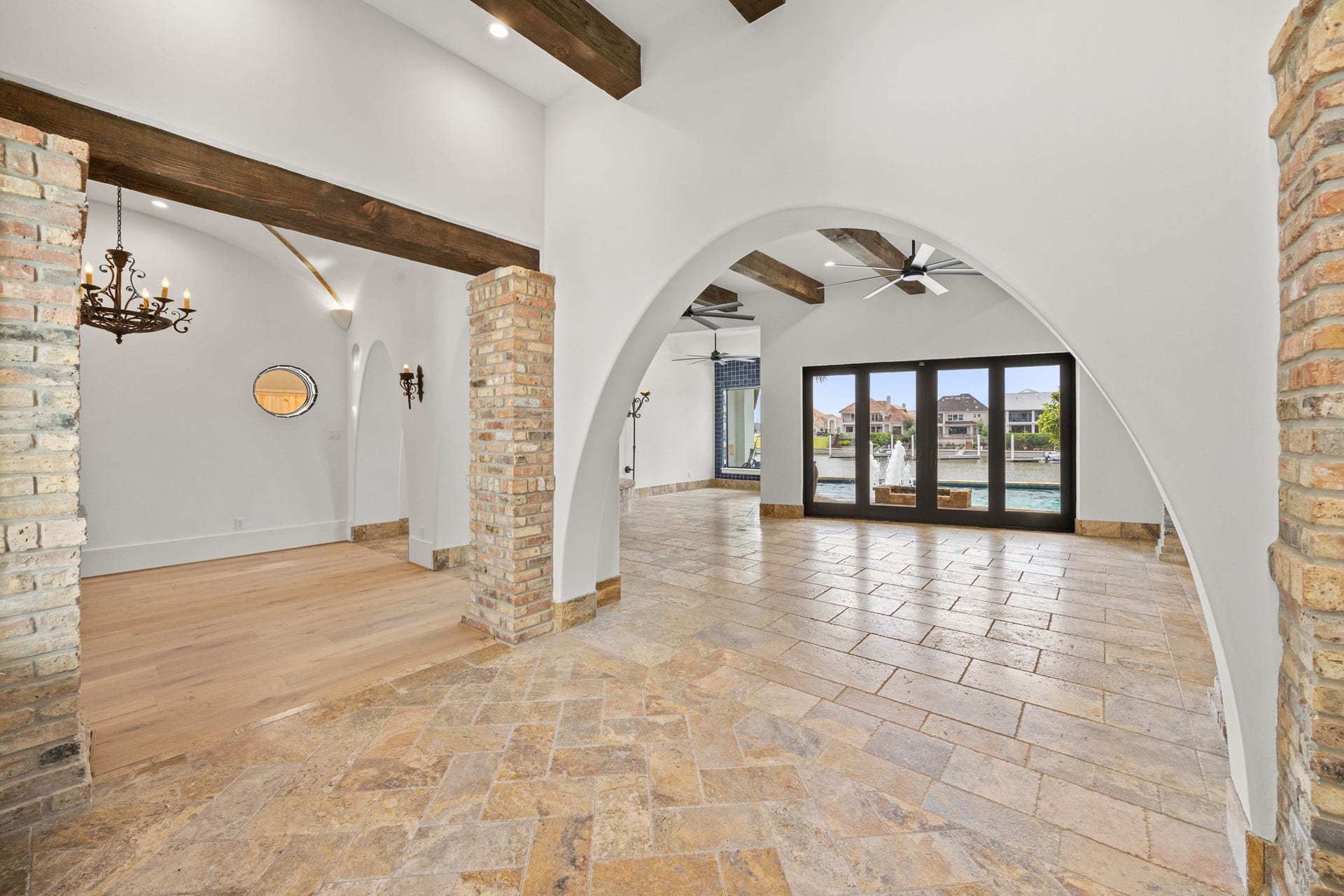 721 Harborside Way, League City, TX 77565 The formal entry is enhanced by rich brick accents and a soaring ceiling, offering stunning sightlines that extend through the home to the pool and marina beyond.