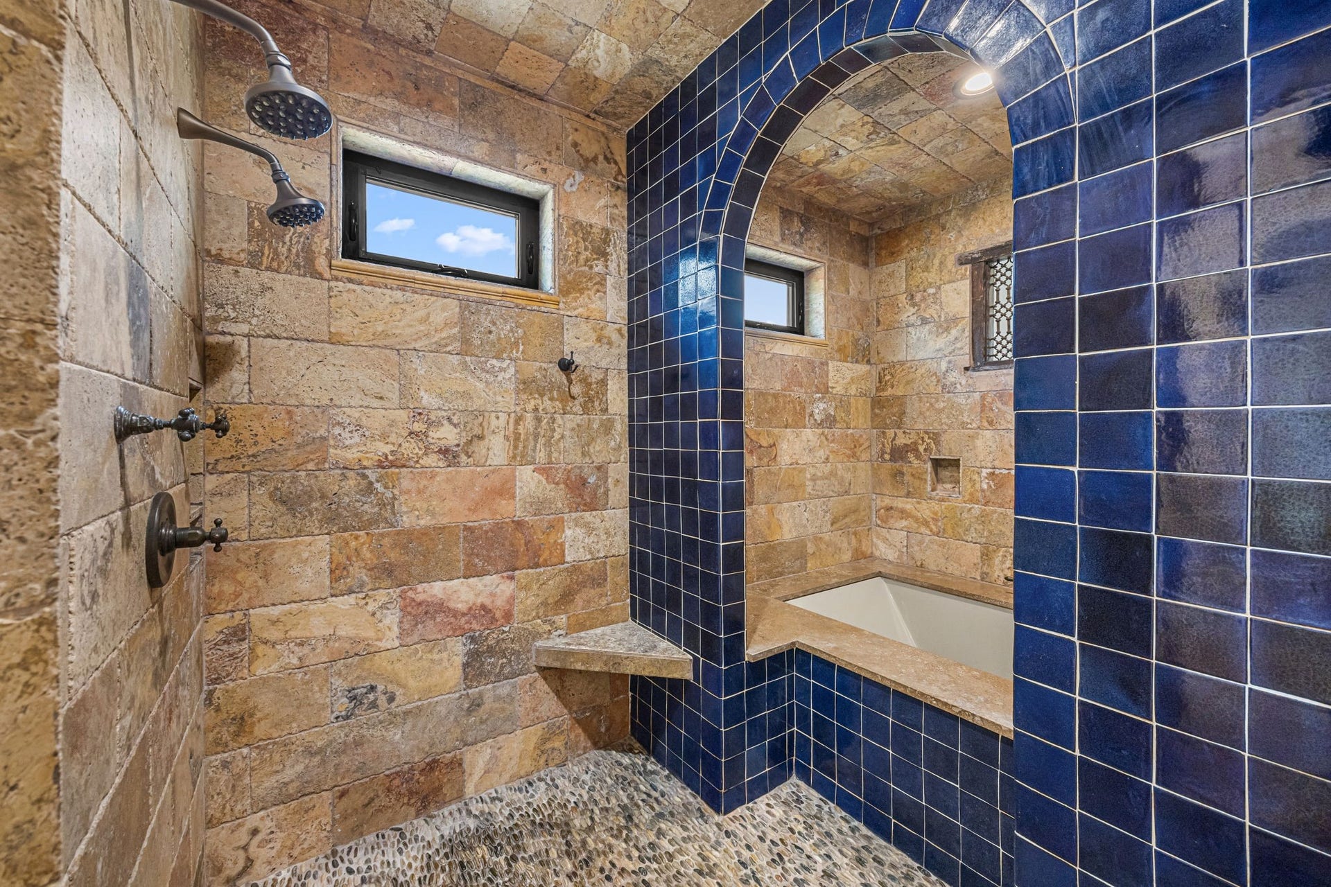 721 Harborside Way, League City, TX 77565 The upstairs primary bath features a spa-inspired wet area with three showers, complemented by travertine and Spanish tile finishes, and a separate soaking tub for ultimate relaxation.