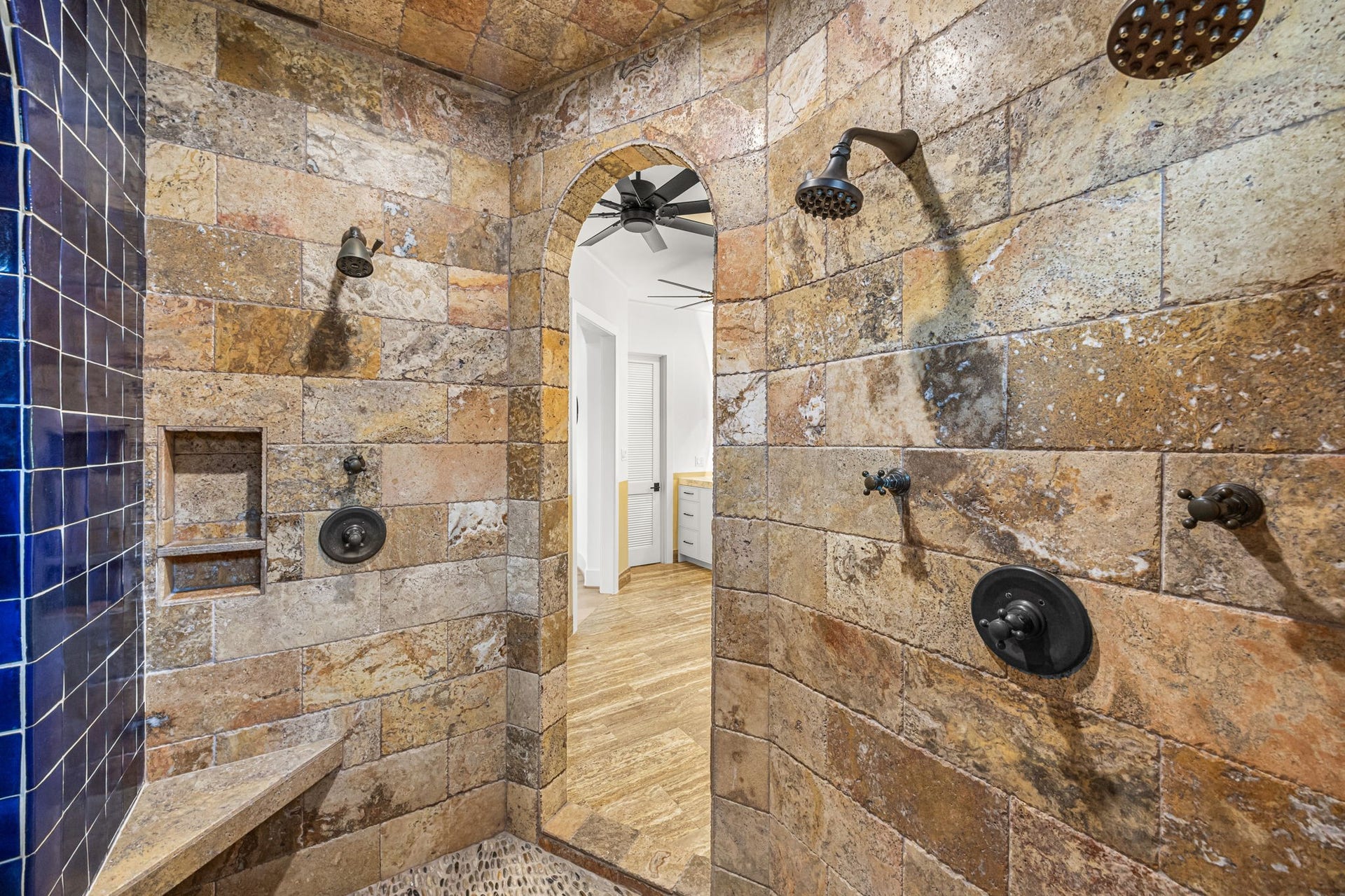 721 Harborside Way, League City, TX 77565 The upstairs primary bath features a spa-inspired wet area with three showers, complemented by travertine and Spanish tile finishes, and a separate soaking tub for ultimate relaxation.