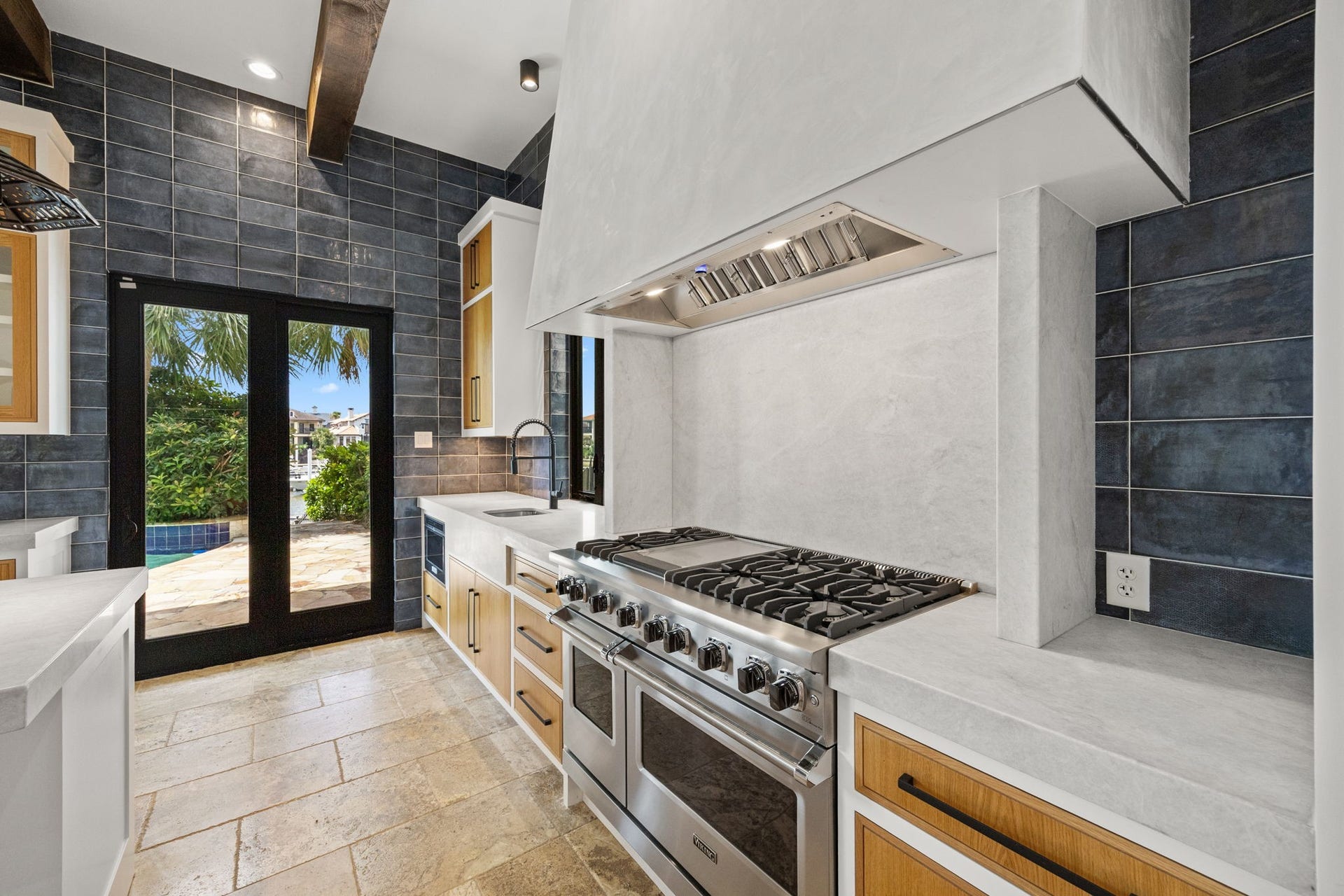 721 Harborside Way, League City, TX 77565 An additional view of the professional Viking range highlights the richly detailed accent wall, showcasing layered textures and refined finishes that elevate the kitchens dramatic focal point.
