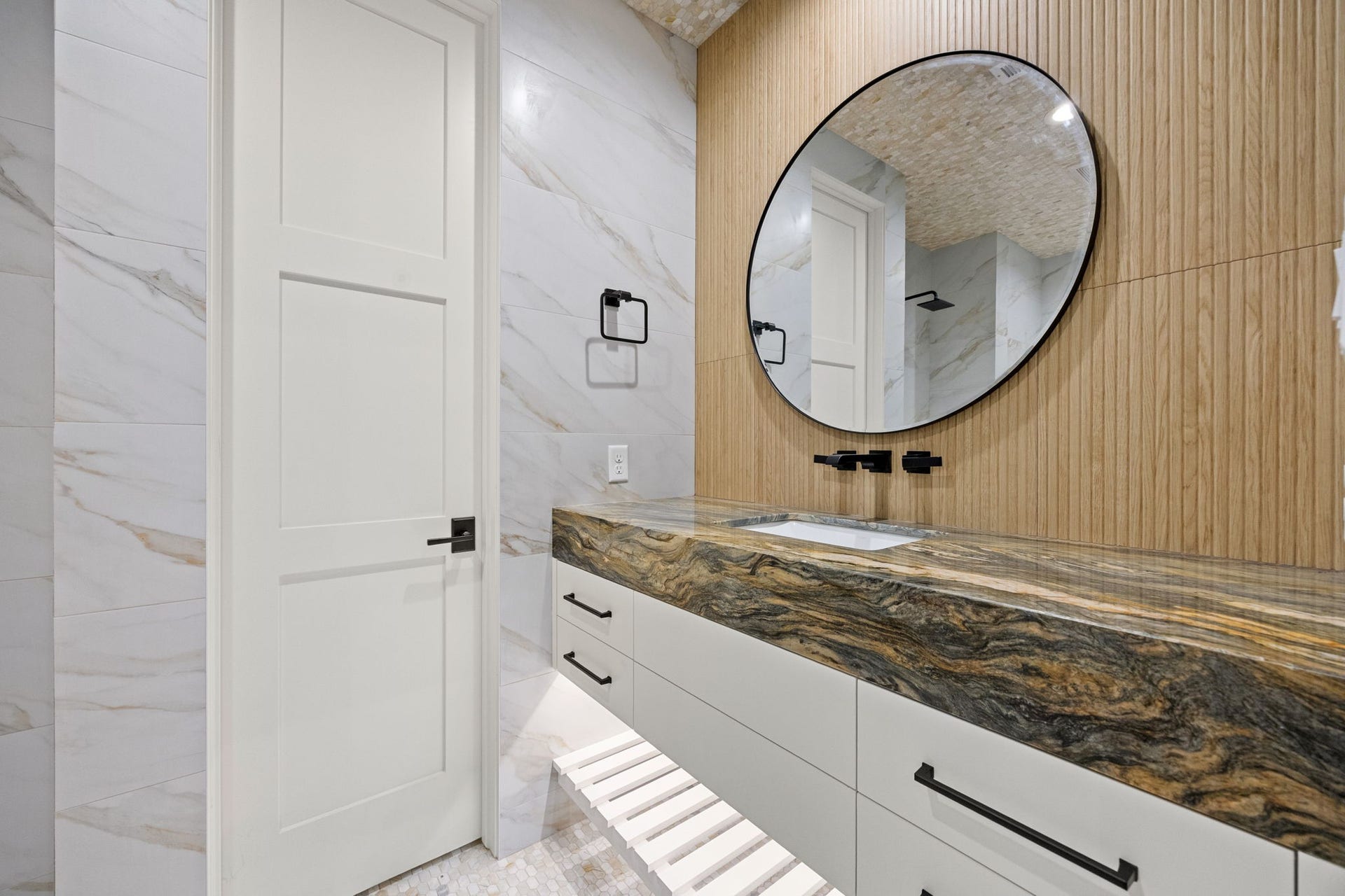 721 Harborside Way, League City, TX 77565 The downstairs primary bath features elegant floating countertops, creating a sleek, modern design with a light and airy feel.