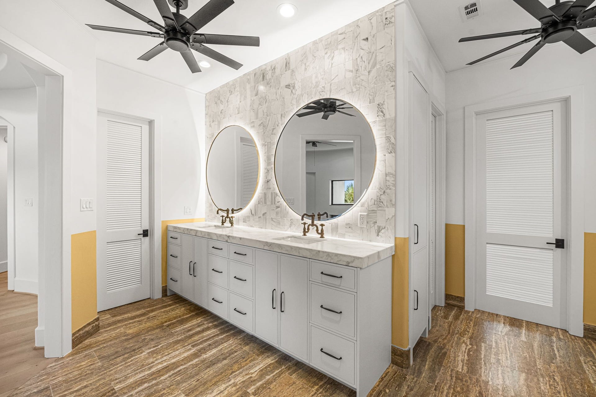 721 Harborside Way, League City, TX 77565 The upstairs primary bath features dual sinks and elegant backlit mirrors, creating a modern and sophisticated vanity space. The bathroom also includes two private water closets, one of which is thoughtfully equipped with a bidet for added comfort and convenience.