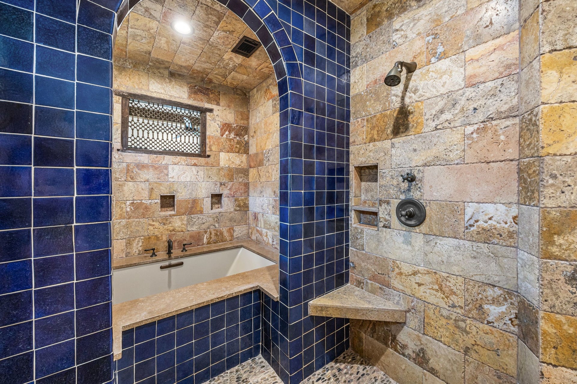 721 Harborside Way, League City, TX 77565 The upstairs primary bath features a spa-inspired wet area with three showers, complemented by travertine and Spanish tile finishes, and a separate soaking tub for ultimate relaxation.