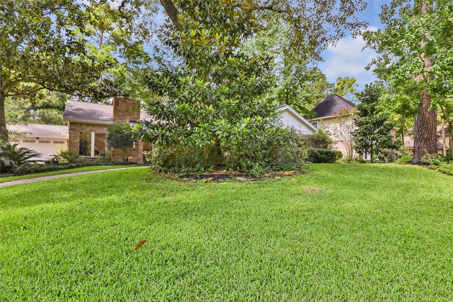 3714 Swift Creek Drive, Kingwood, TX 77339 Expansive, lush green lawn surrounded by mature trees offers a serene and private setting for this charming home.