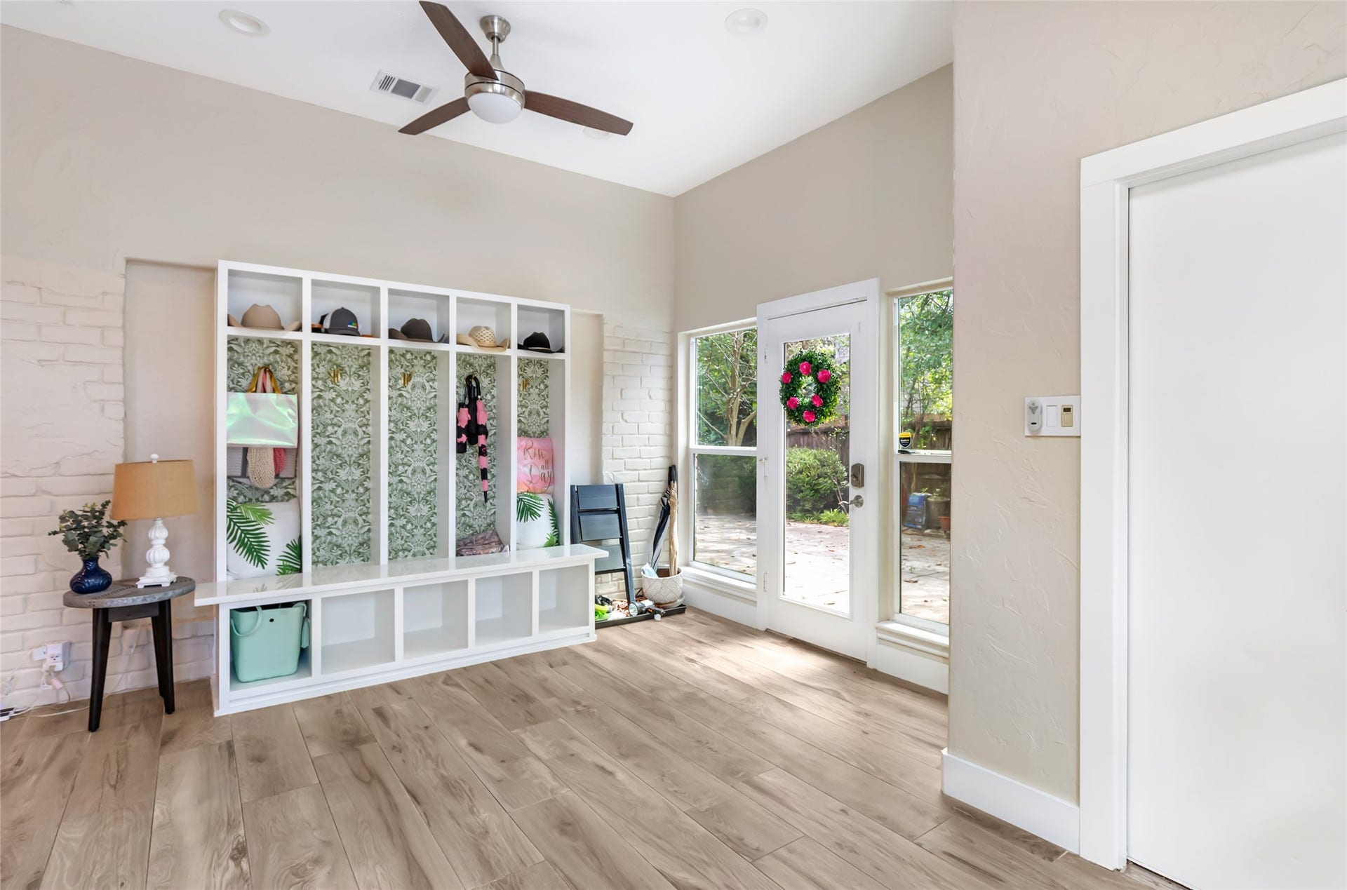 3714 Swift Creek Drive, Kingwood, TX 77339 Bright and welcoming sunroom/mudroom featuring stylish built-in storage, leads into garage and has abundant natural light from large windows and a glass door leading to the outdoor pool area.