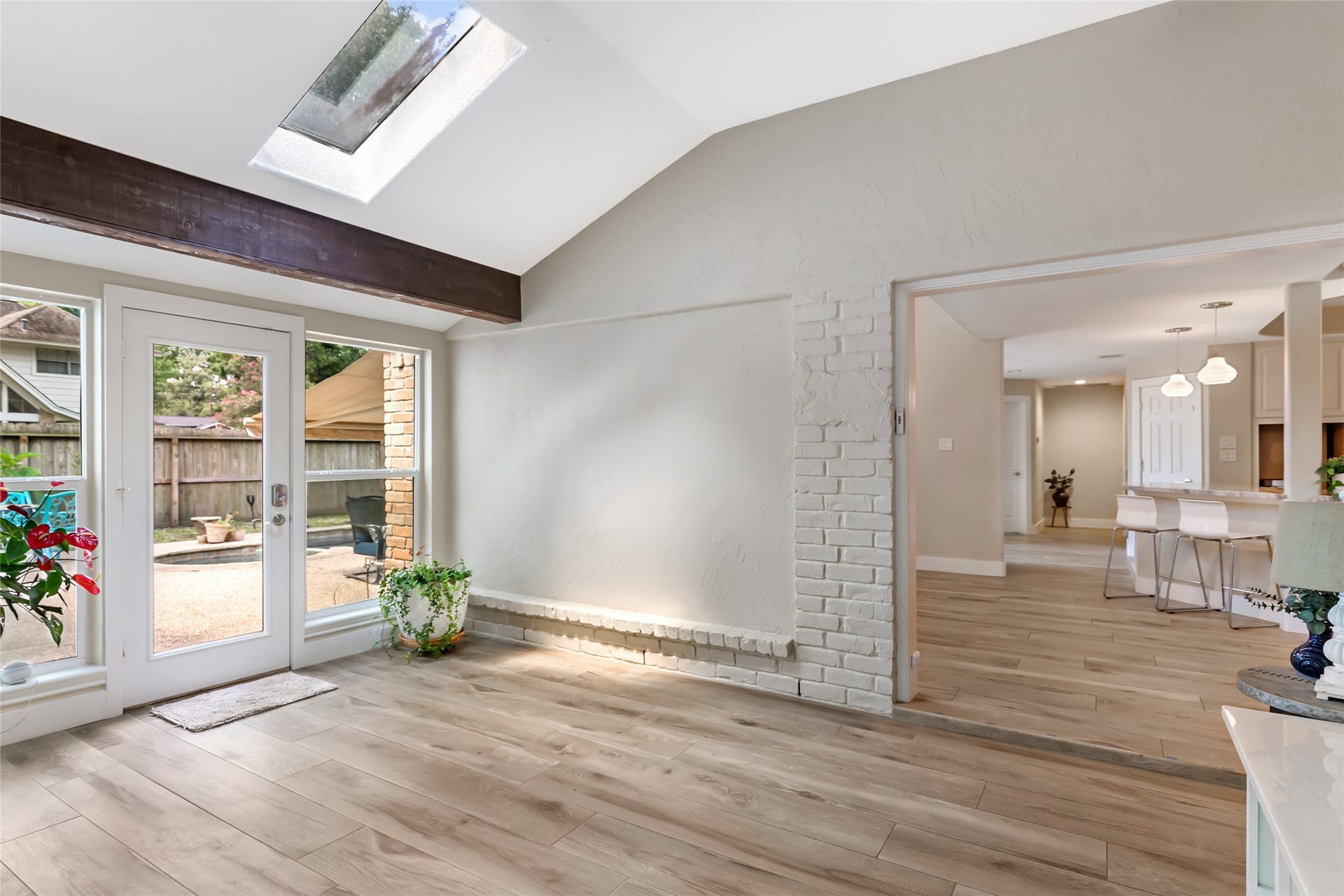 3714 Swift Creek Drive, Kingwood, TX 77339 Bright and inviting sunroom with skylight, elegant wood flooring, and French doors leading to a serene patio. Open layout seamlessly connects to the modern kitchen and dining area.