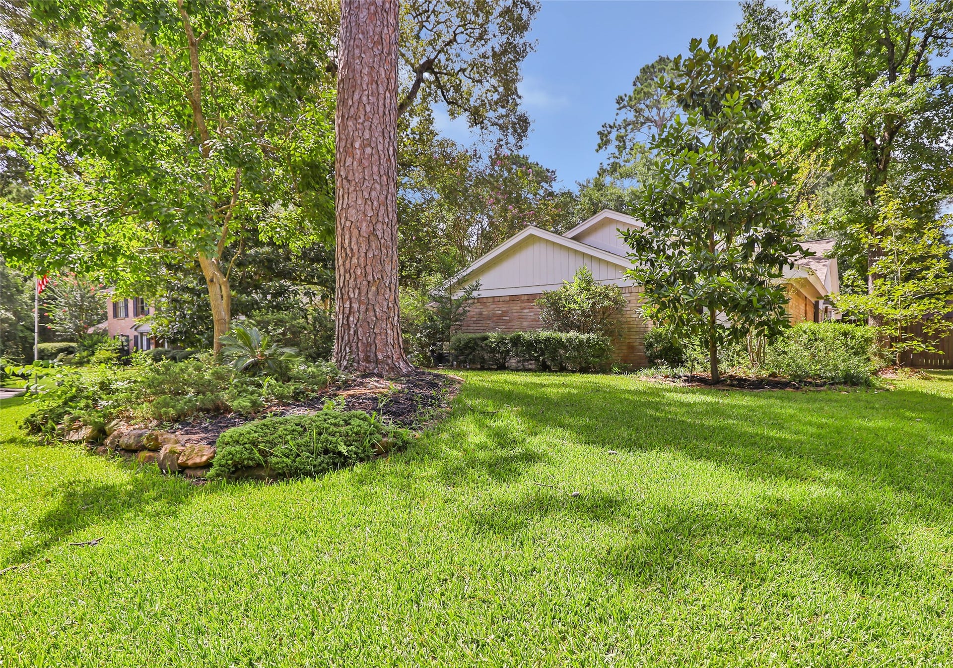 3714 Swift Creek Drive, Kingwood, TX 77339 Expansive green lawn framed by mature trees and lush landscaping offers a serene, private setting for this charming home.