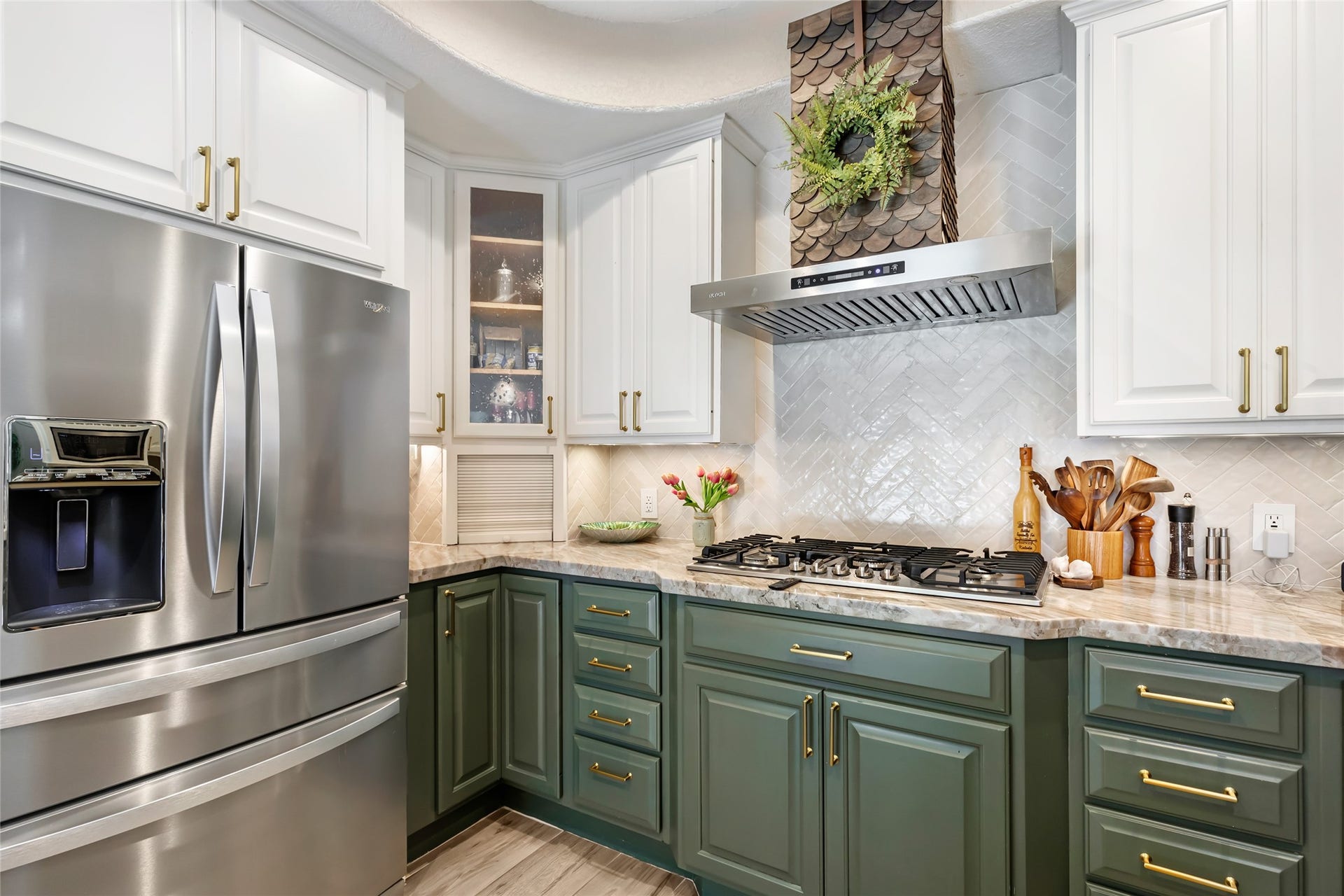 3714 Swift Creek Drive, Kingwood, TX 77339 Charming kitchen with elegant two-tone cabinetry, featuring green lower cabinets and white uppers, includes a Chef's dream 1200 CFM vent hood and AMZCHEF gas cooktop!