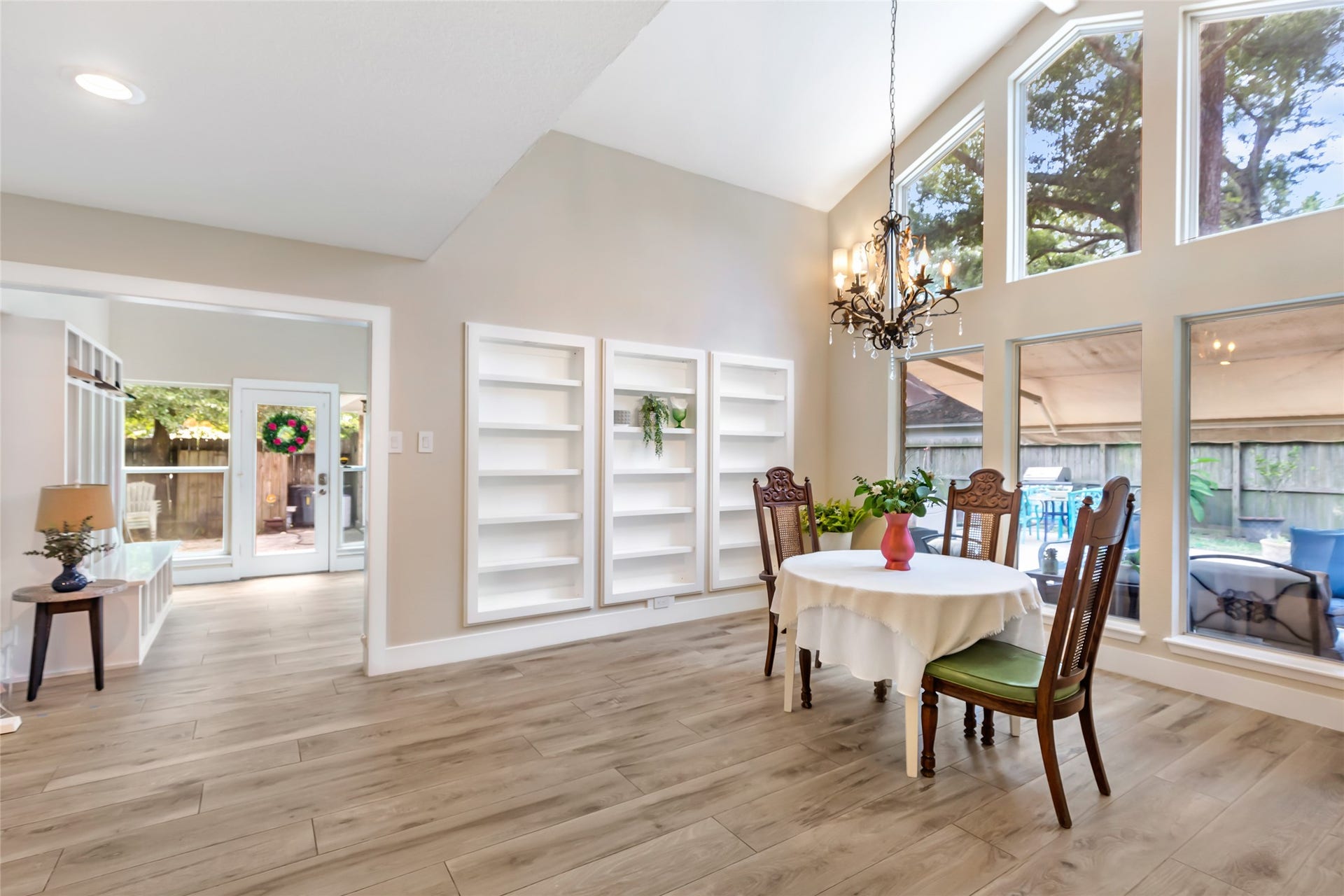 3714 Swift Creek Drive, Kingwood, TX 77339 Bright dining area with high ceilings, elegant chandelier, built in shelves, and expansive windows offering a view of the backyard.