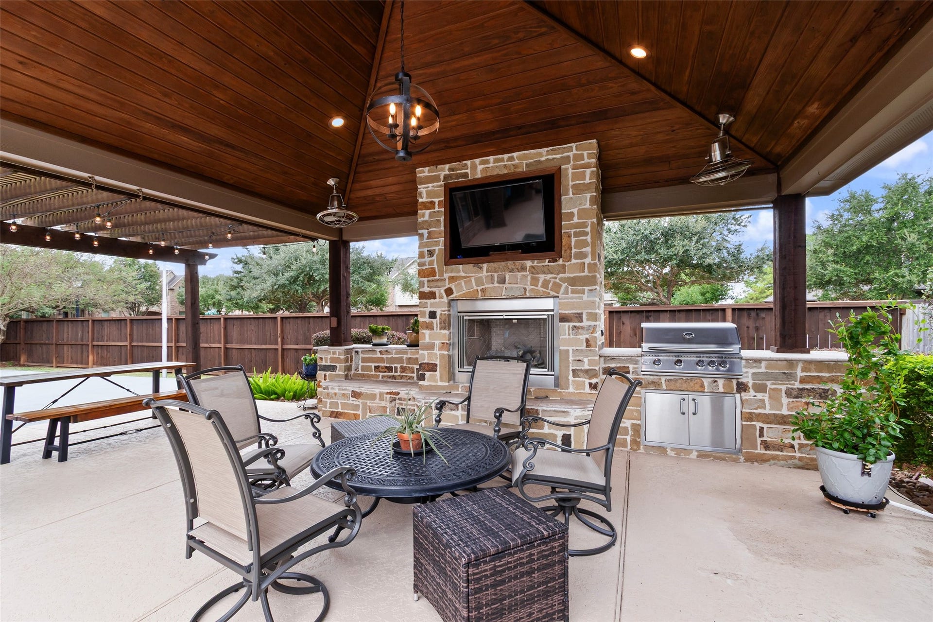 21114 W Kelsey Creek Trail, Cypress, TX 77433 Another look at the covered pergola with outdoor lighting/fan, and a better look at the gas grill and prep space. On the other side of the long table/bench is the beginning of the sport court. There is something for everyone right in your own backyard.