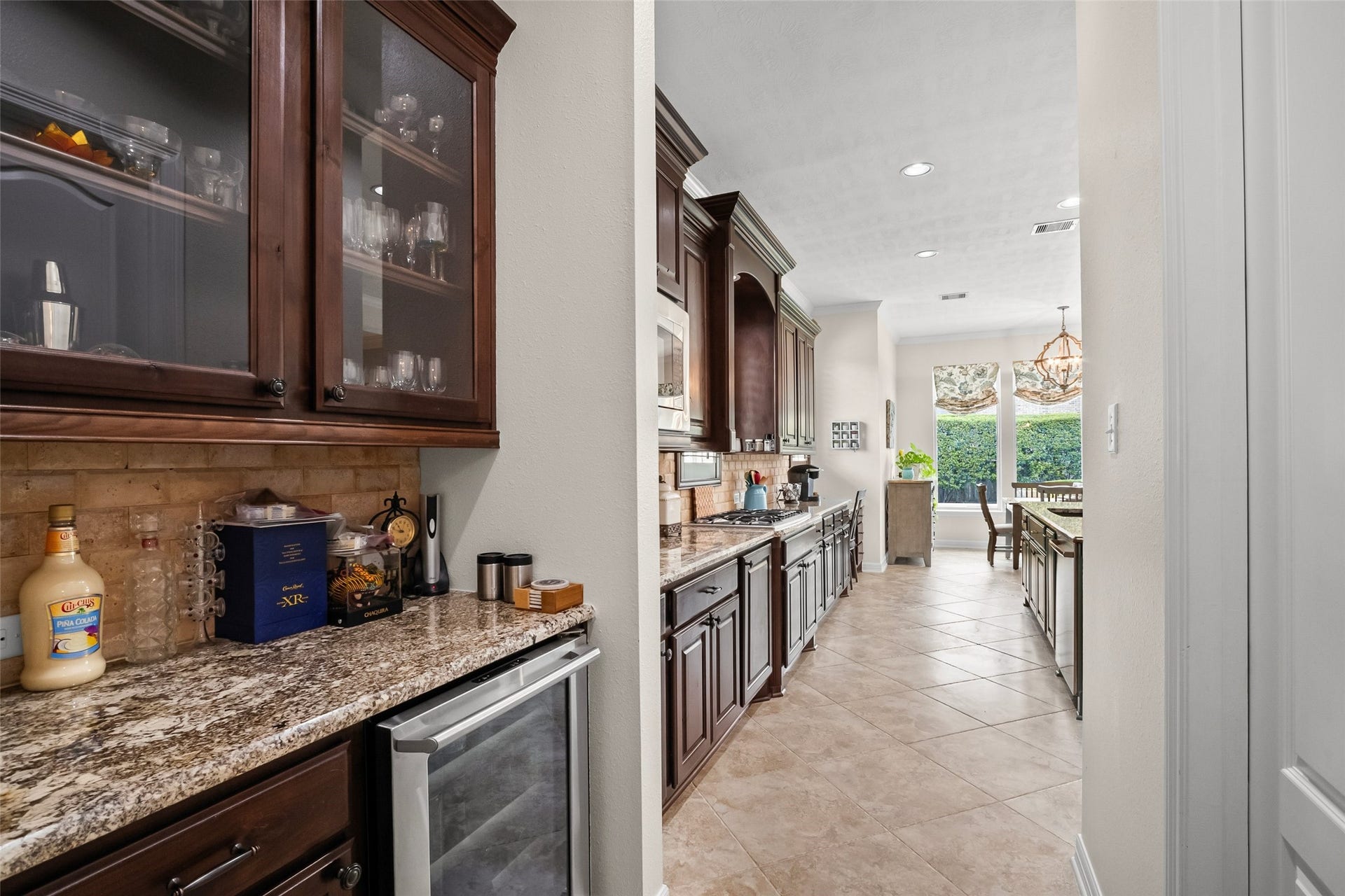 21114 W Kelsey Creek Trail, Cypress, TX 77433 Butler pantry that includes a wine chiller past that is another view of the kitchen. Large walk-in pantry is located to the right behind the door. Look at all of the cabinets! No shortage of storage space in this home.