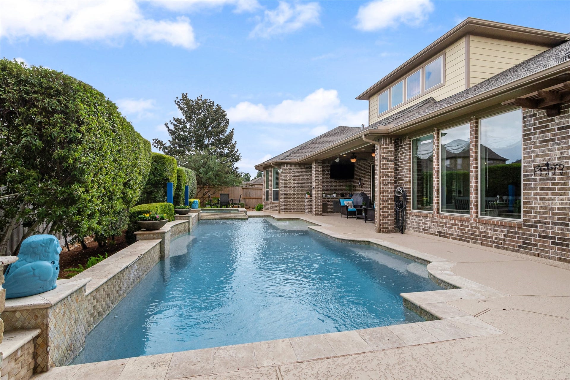 21114 W Kelsey Creek Trail, Cypress, TX 77433 Looking across the pool/spa from the other direction. Notice the natural looking stone that surrounds the pool and graces the short wall behind the pool. The location of the covered patio can be seen here.